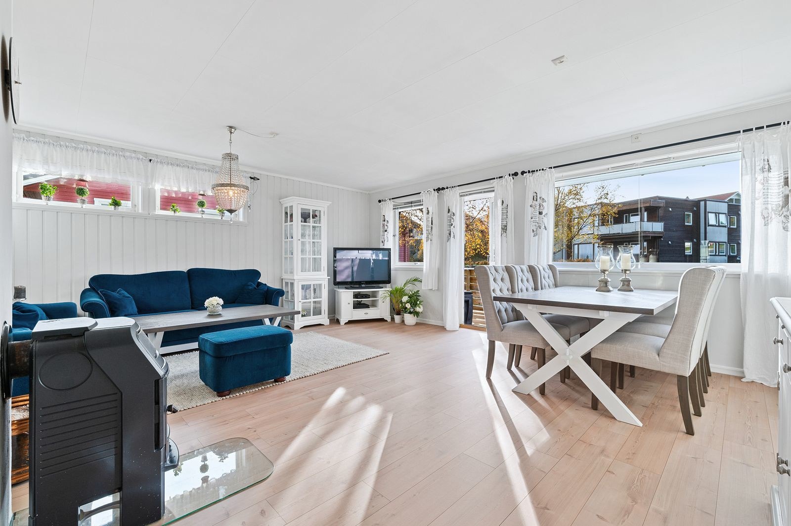 Stue med godt lysinnslipp fra flere vindusflater. Galleribilde