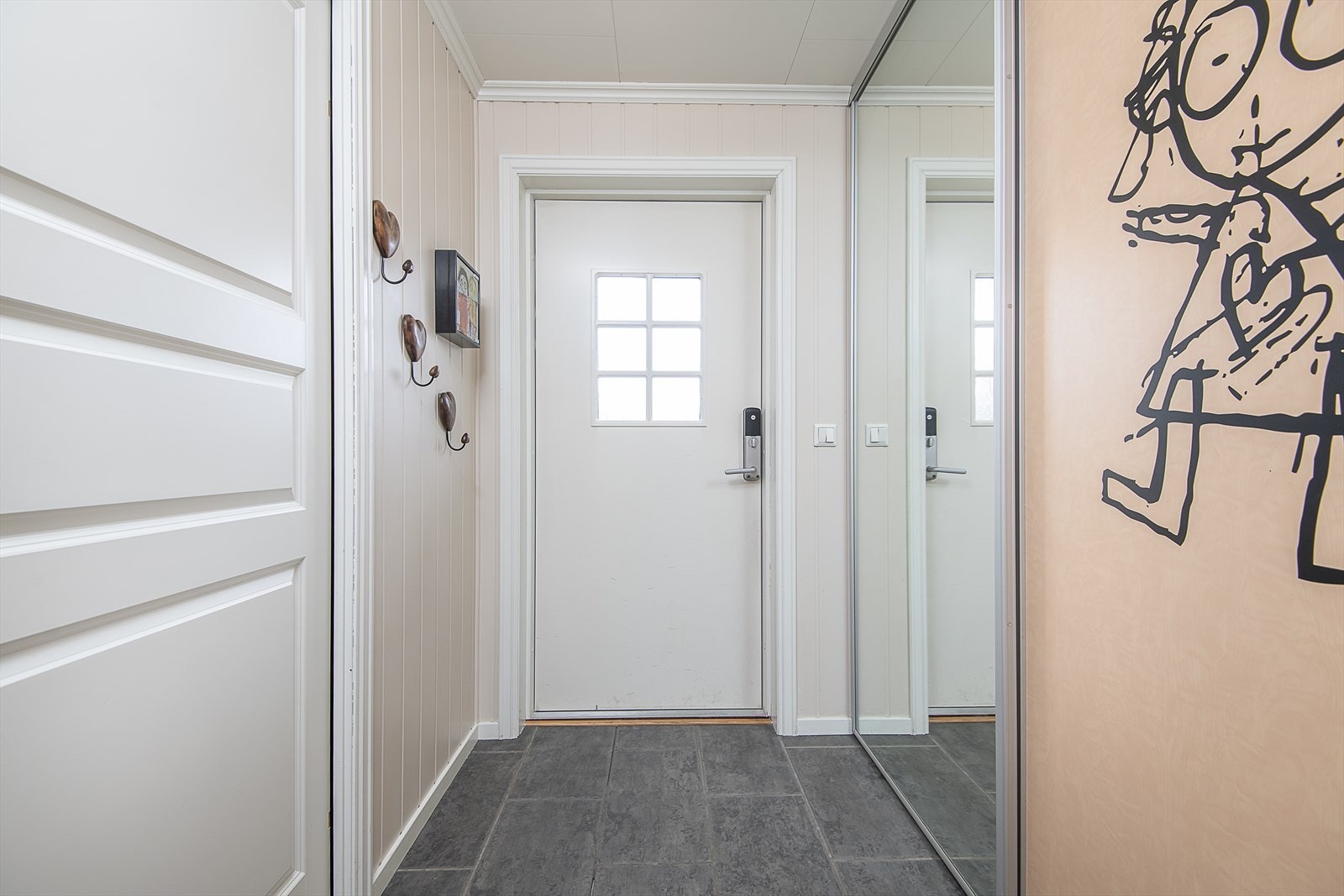 Romslig gang er innredet med skyvedørsgarderobe og har varme i gulv Galleribilde