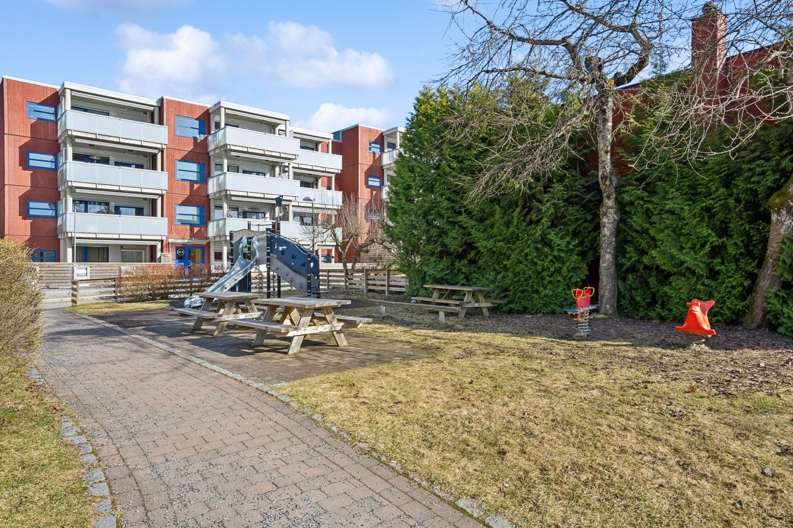 Uteområde med sittebrupper og lekeapparater Galleribilde