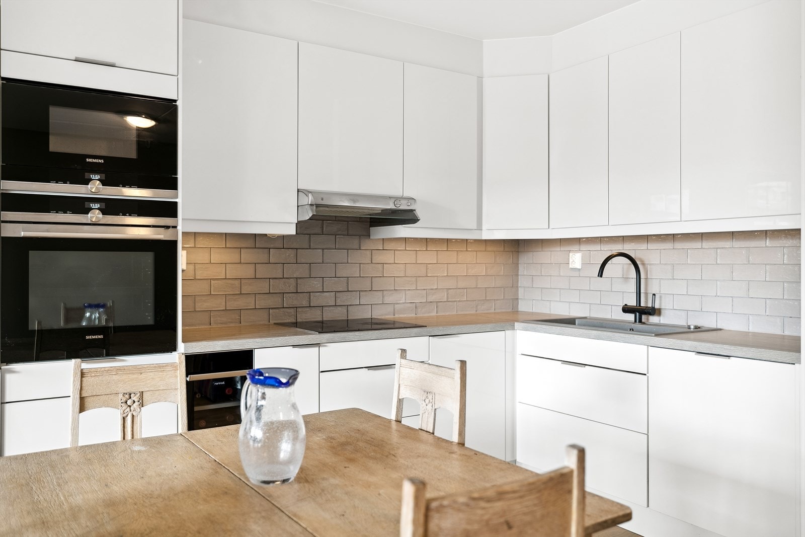 I innredningen er det integrerte hvitevarer som mikro og stekeovn i ståhøyde, platetopp, oppvaskmaskin og kjøle-/fryseskap Galleribilde