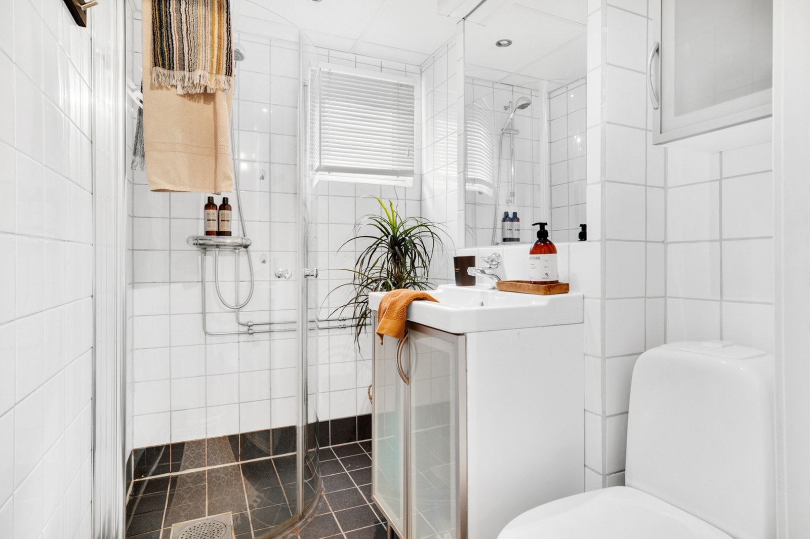 Badet har en åpen dusjløsning med innfellbare glassvegger. Galleribilde