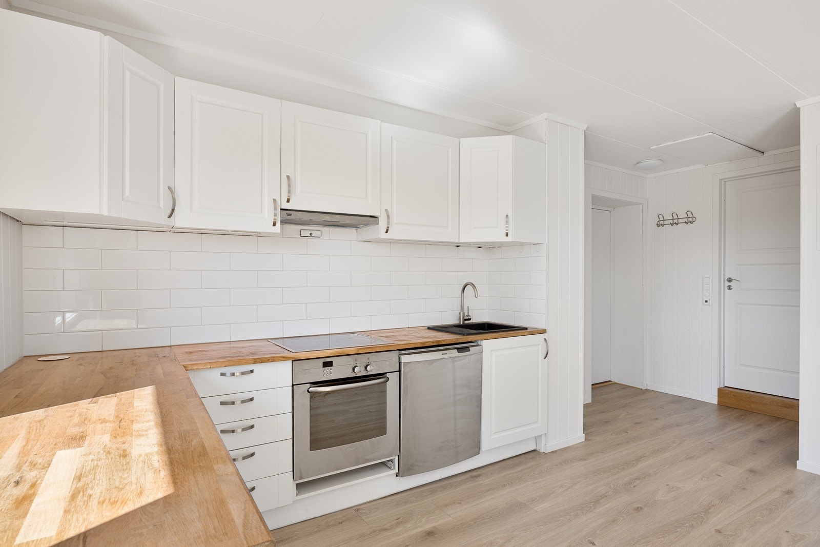 Innredningen er holdt i en klassisk stil med hvite, profilerte fronter, benkeplate av heltre og nedfelt oppvaskkum Galleribilde