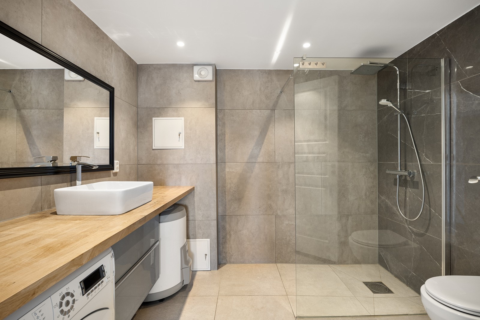 Badet ble oppgradert i 2022 og gir et delikat inntrykk med store fliser på overflater, gulvvarme og downlights Galleribilde