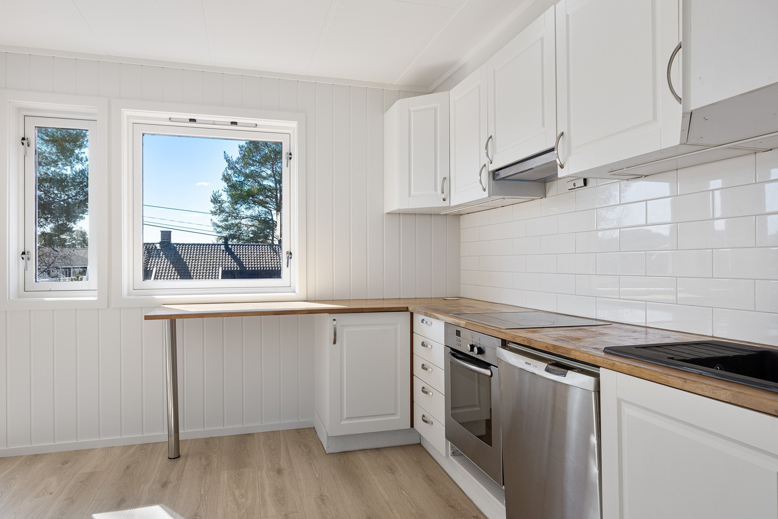 Kjøkkenet har en fin spiseplass ved barløsning under vinduet Galleribilde