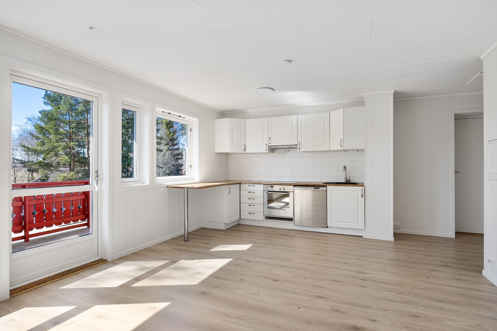 Kjøkkenet ligger i åpen løsning mot stuen med innredning langs to vegger Galleribilde