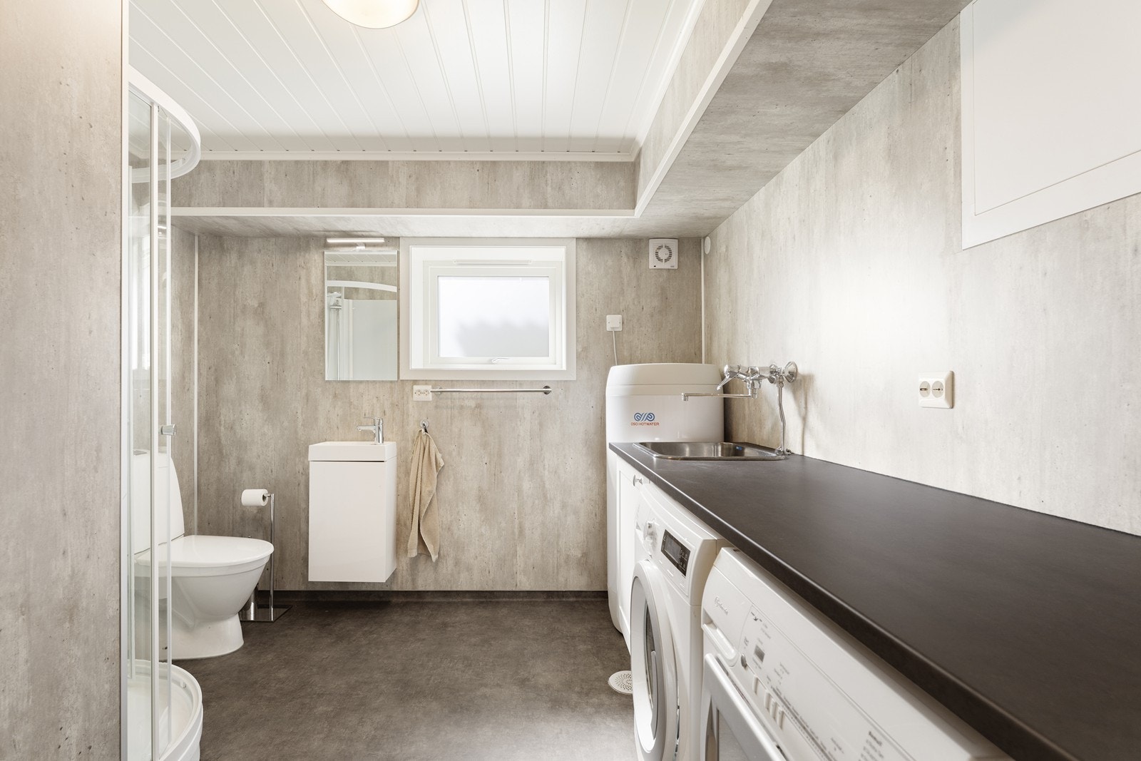 Nyere bad/vaskerom med vinylbelegg på gulv og baderomsplater på vegg. Galleribilde