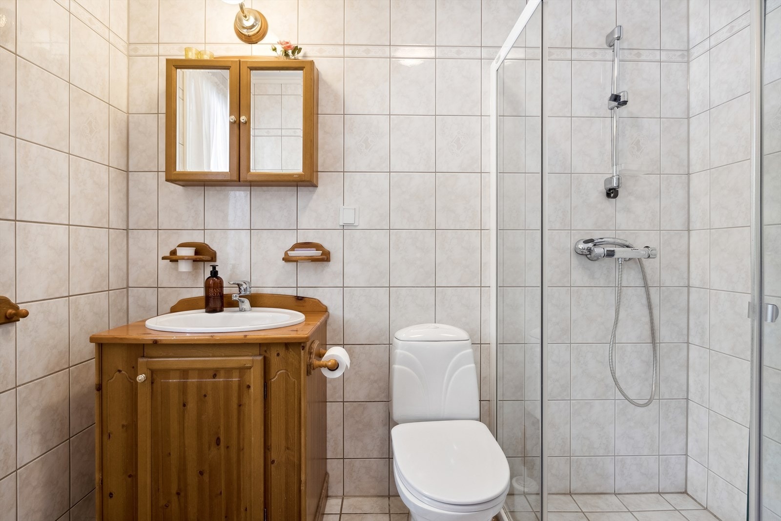 Flislagt baderom i 1. etasje med nedfelt servant, toalett og dusj på vegg. Nytt toalett i 2023. Galleribilde