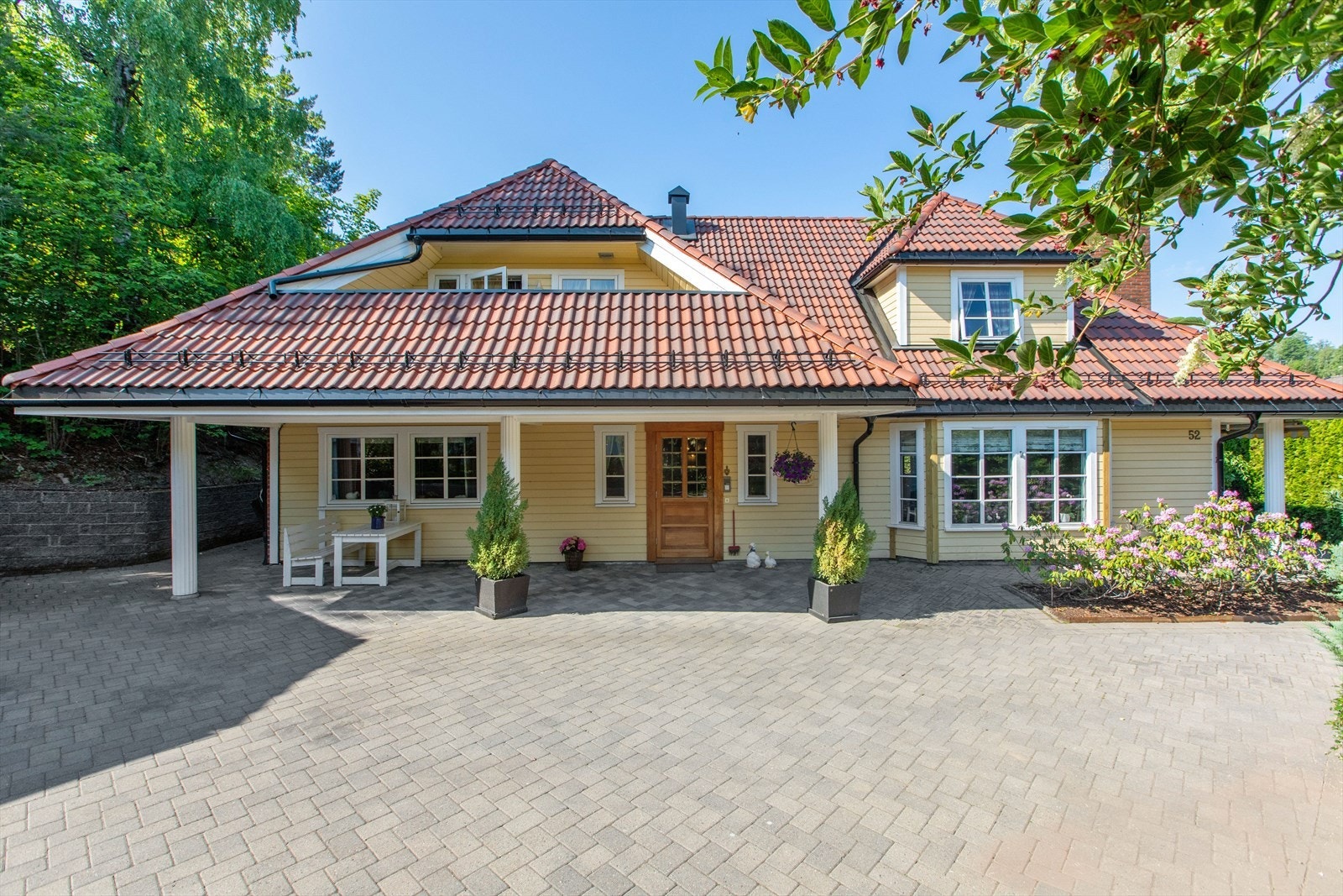 Tiltalende enebolig med flott inngangsparti og stor, stenlagt gårdsplass. Galleribilde