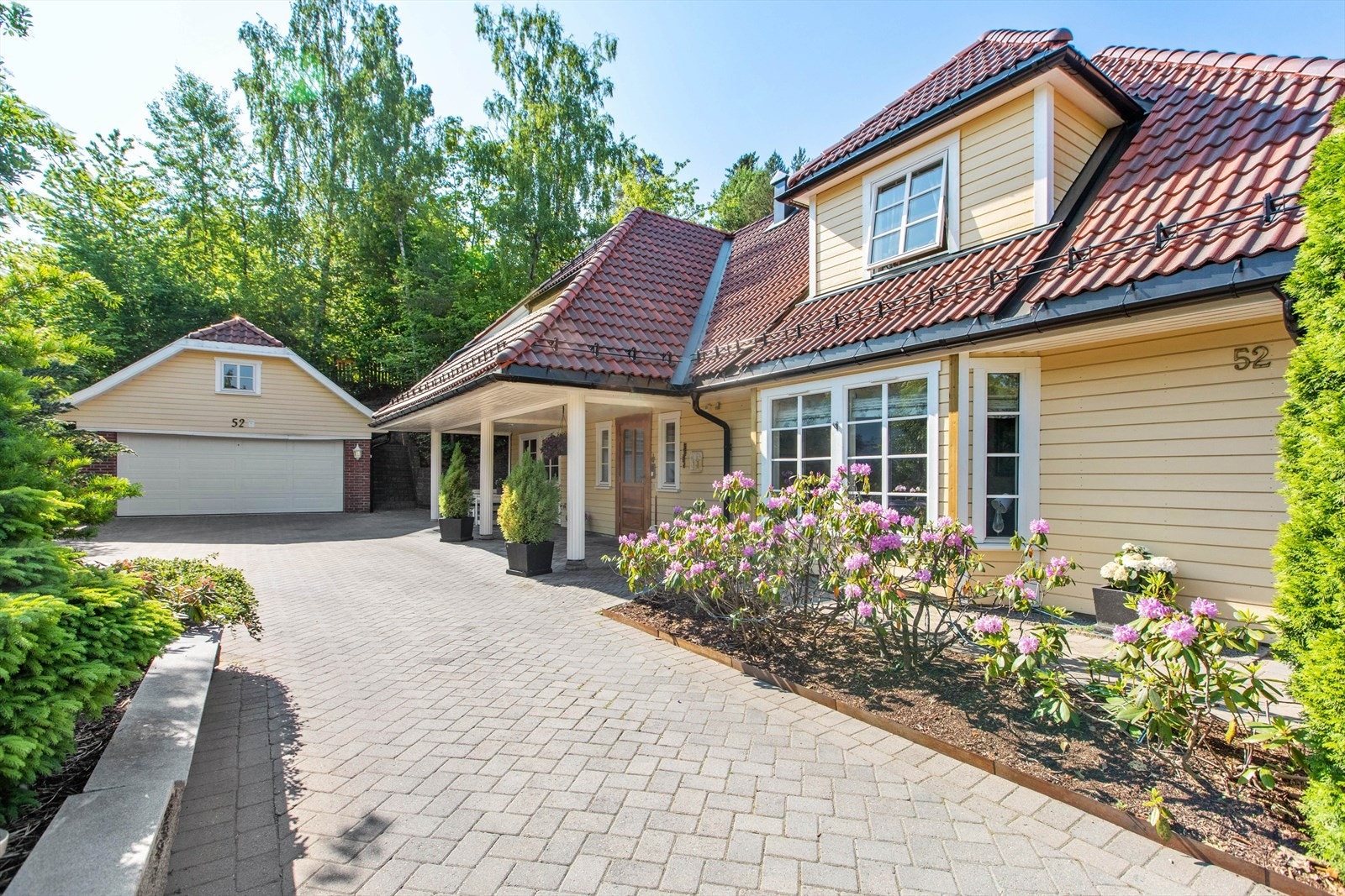 Flat og fin adkomst fra veien, gode parkeringsmuligheter i stor dobbelgarasje på 38 kvm med leddport i stål med automatisk åpner Galleribilde