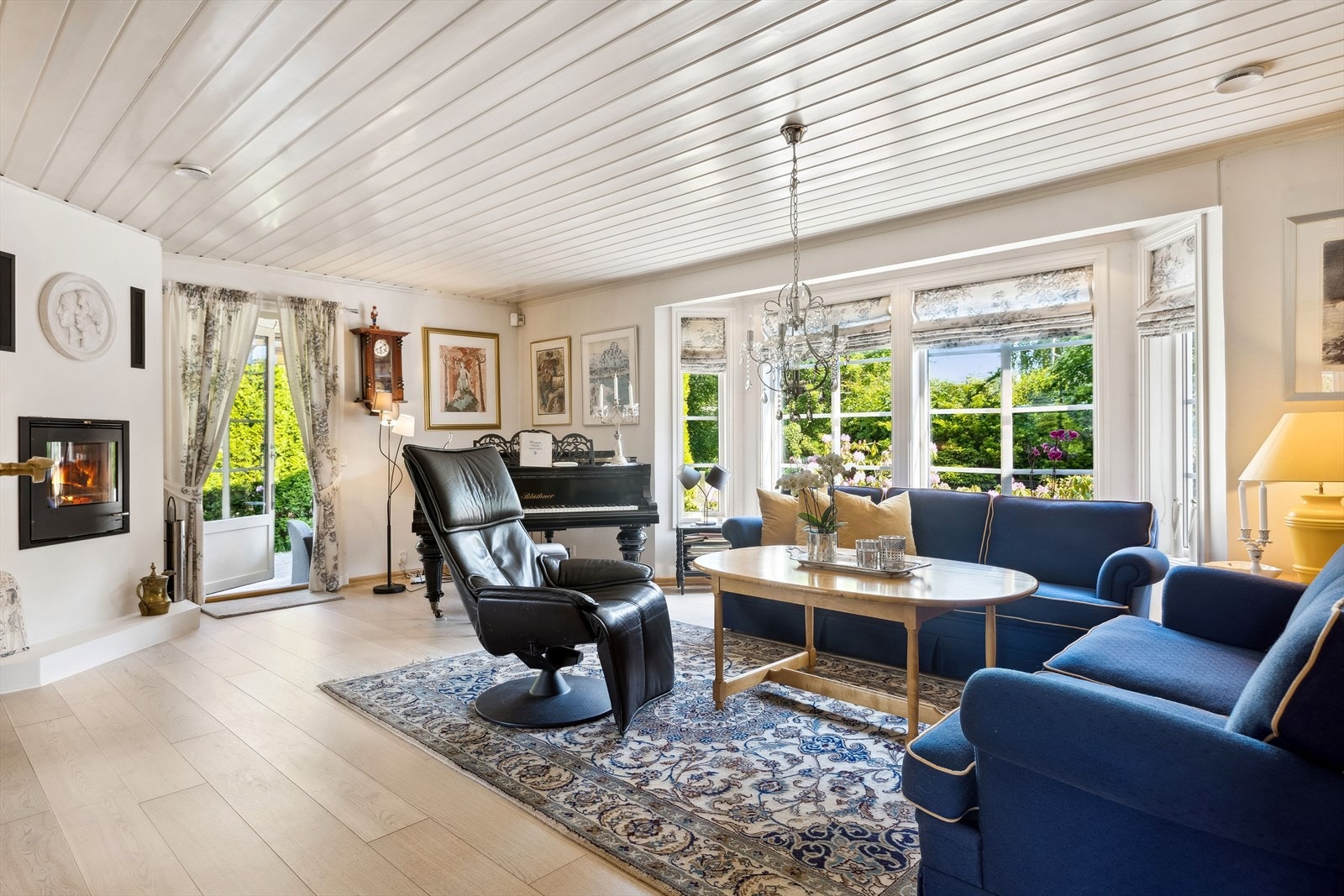 Stuen har store vindusflater som gir rommet mye naturlig lys, og peisen gir godt med varme. Galleribilde