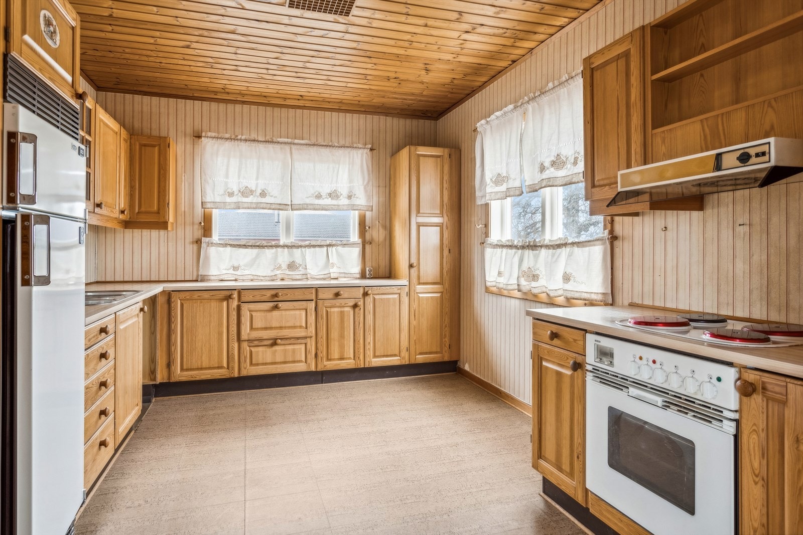 Kjøkkenet er ca 13,7 m² og har innredning bestående av heltre skrog med slette fronter og laminert benkeplate dels benkeplate i stål. Galleribilde