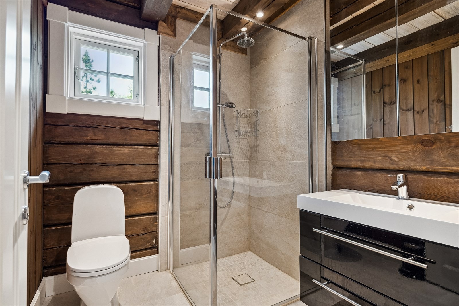 Badet i annekset er utstyrt med servant med innredning, gulvstående toalett og dusjnisje. Galleribilde