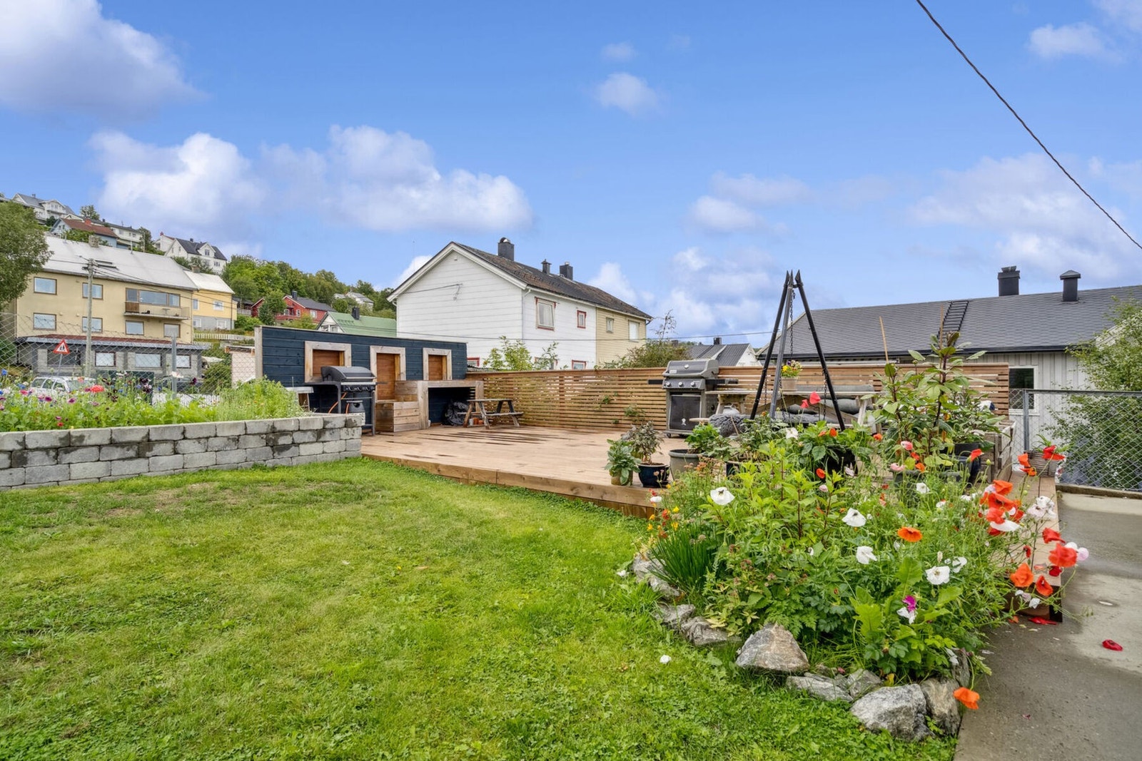 Flott opparbeidet markterrasse for sameiet med blomsterbed. Galleribilde