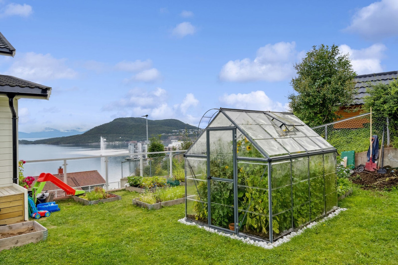 Fellesarealet er opparbeidet med drivhus og flere blomsterbed og blomsterkasser. Galleribilde
