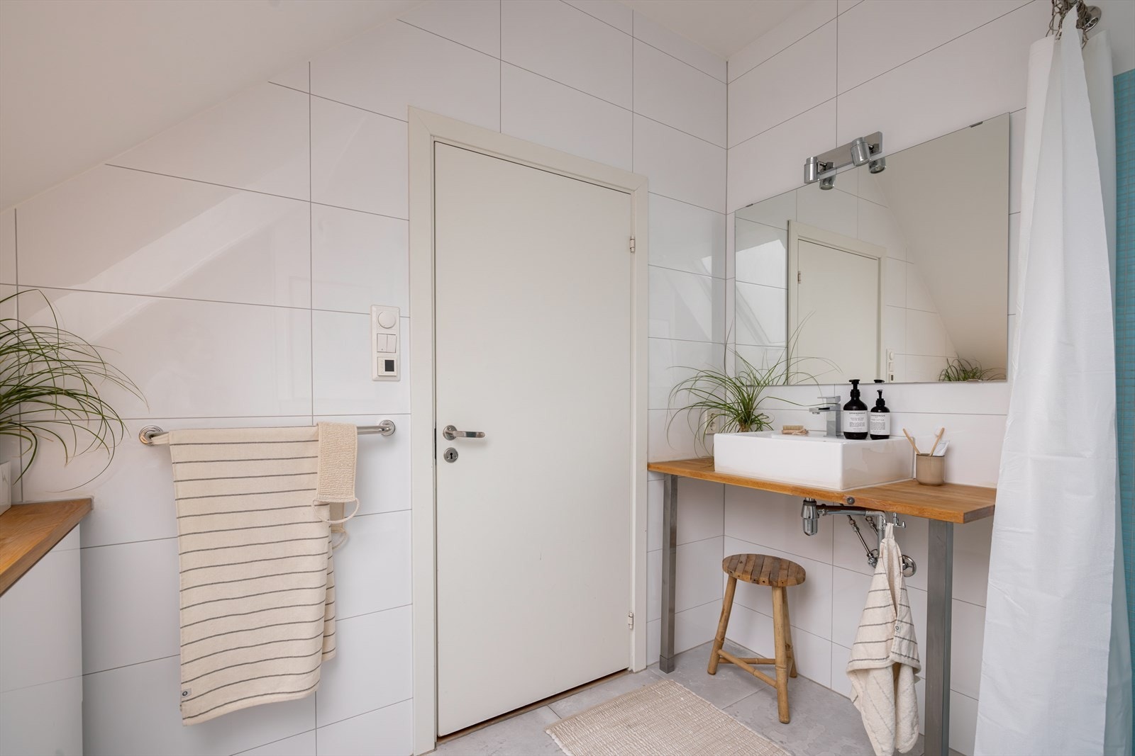 Badet er særdeles kvadratsmart, og innredet med servant på benkeplate, vegghengt toalett og hjørnedusj. Det er også opplegg for vaskemaskin på badet, flott plassert under arbeidsbenk. Galleribilde