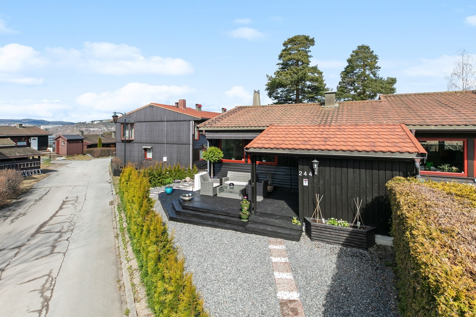 Pent inngangsparti med gruslagt gårdsplass og nybeiset platting og trapp. Galleribilde