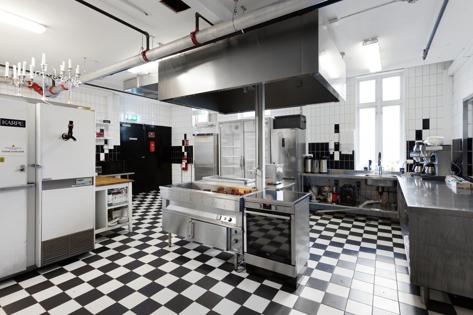 Hovedkjøkkenet ligger i andre etasje og er et stort, praktisk rom med god standard og komplett innredning i syrefast stål av nyere dato. Rommet har sjakkmønstret flisgulv, fliser på veggene og alt av hvitevarer for et storkjøkken. Galleribilde