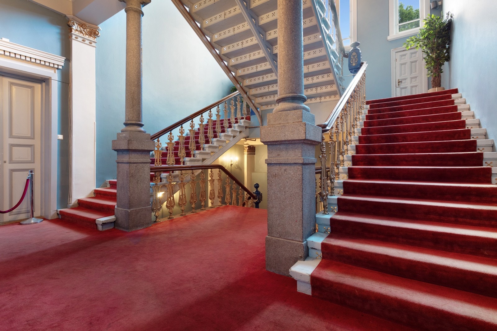 Første til tredje etasje bindes sammen av et flott trapperom med rødt gulvteppe og bred, teppebelagt trapp. Galleribilde