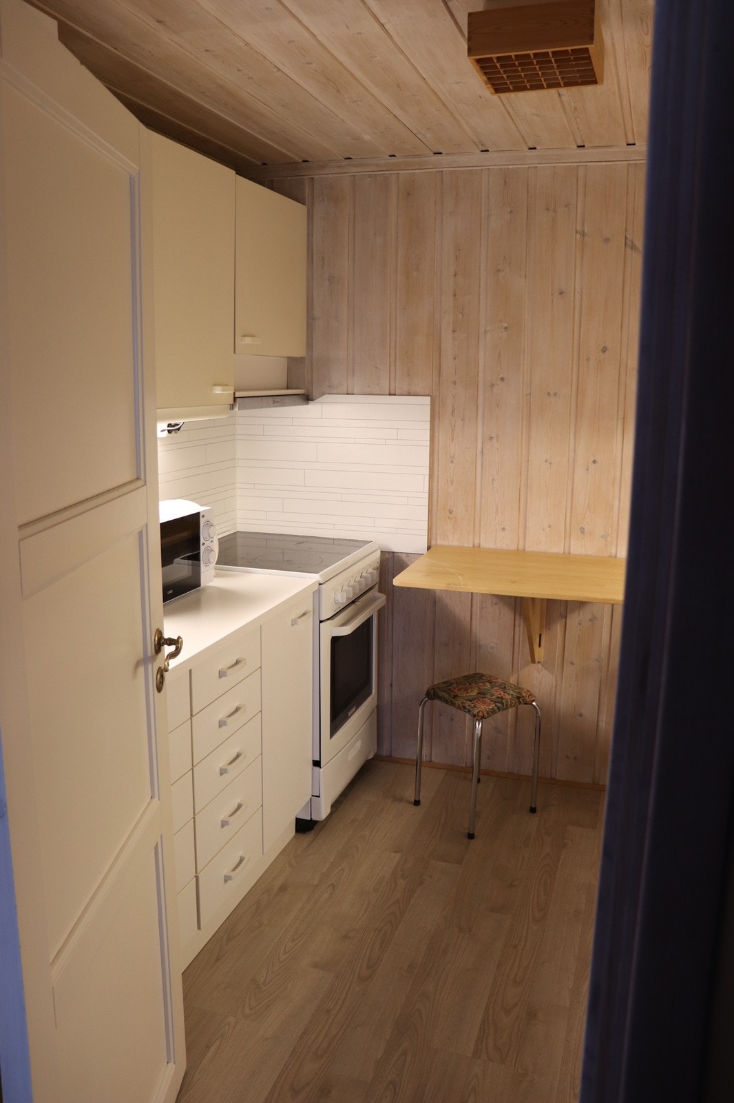 Kjøkken med oppvaskmaskin, mikrobølgeovn, ovn, kjøleskap og vannkoker Galleribilde