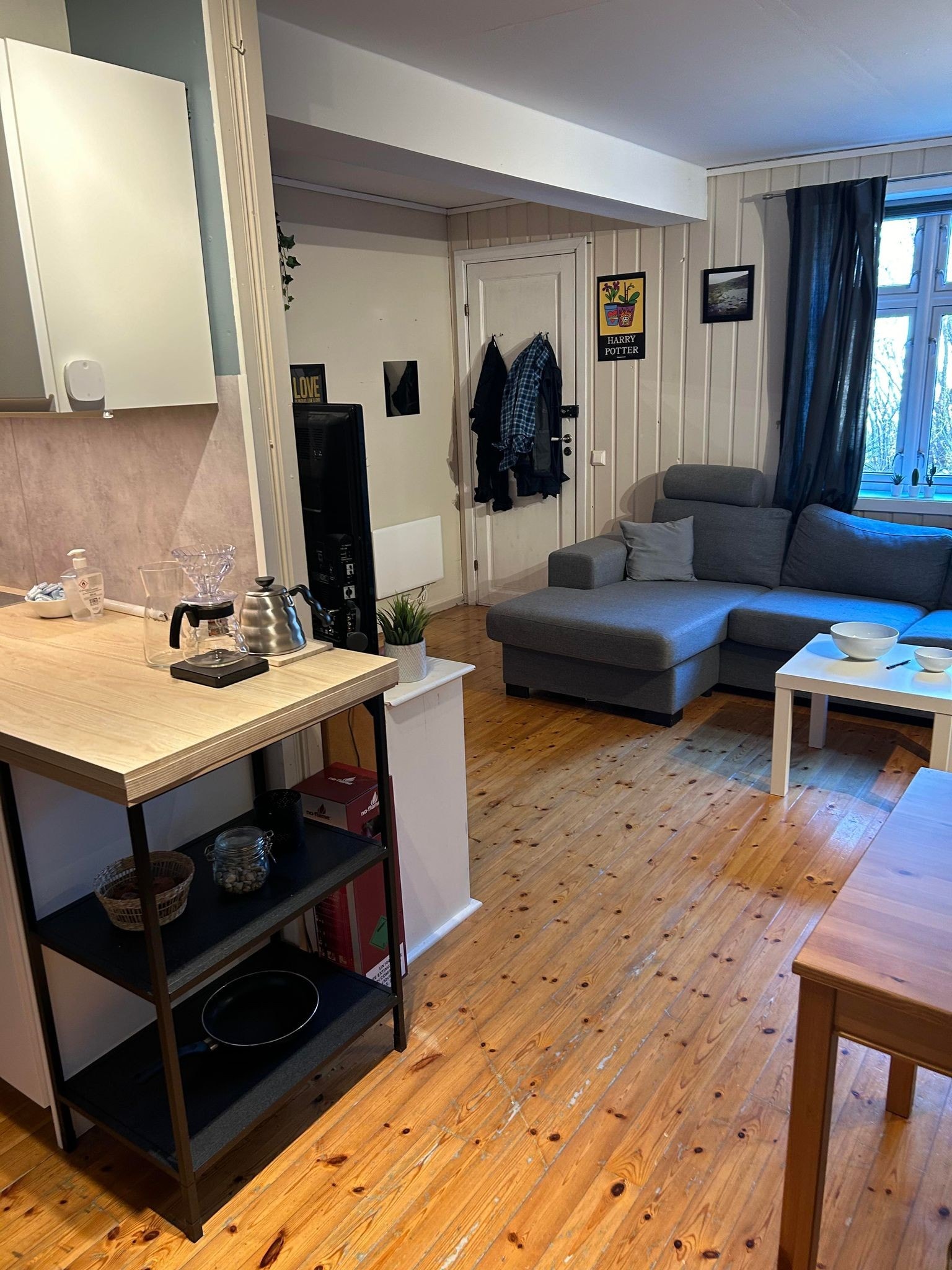 Åpen stue/kjøkken. Sofa, bord, kjøleskap med frys og komfyr. Galleribilde
