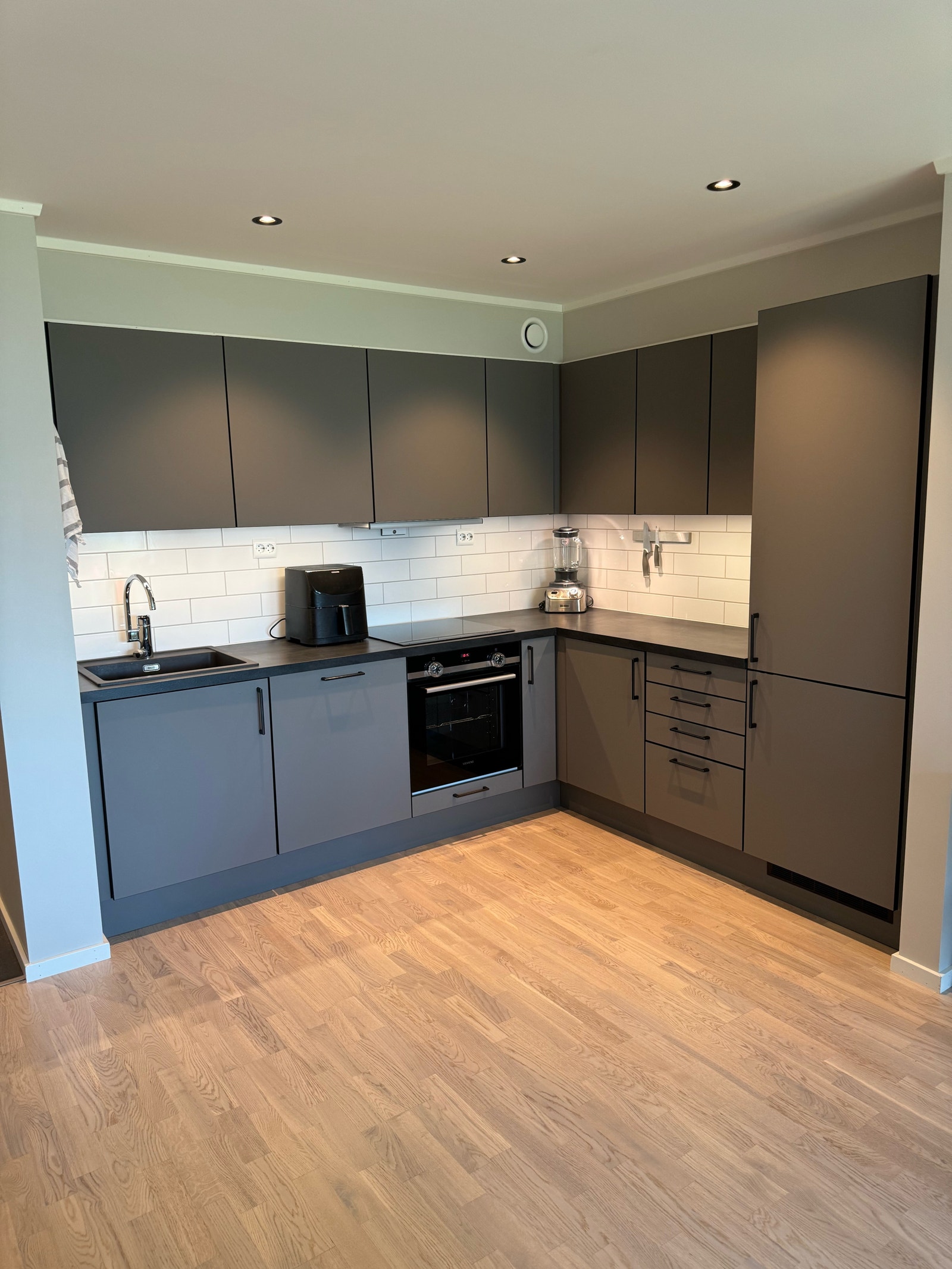 Åpen stue/kjøkken-løsning. Dimbare ledspots i taket ved kjøkkenet for stemningsfull og god belysning Galleribilde