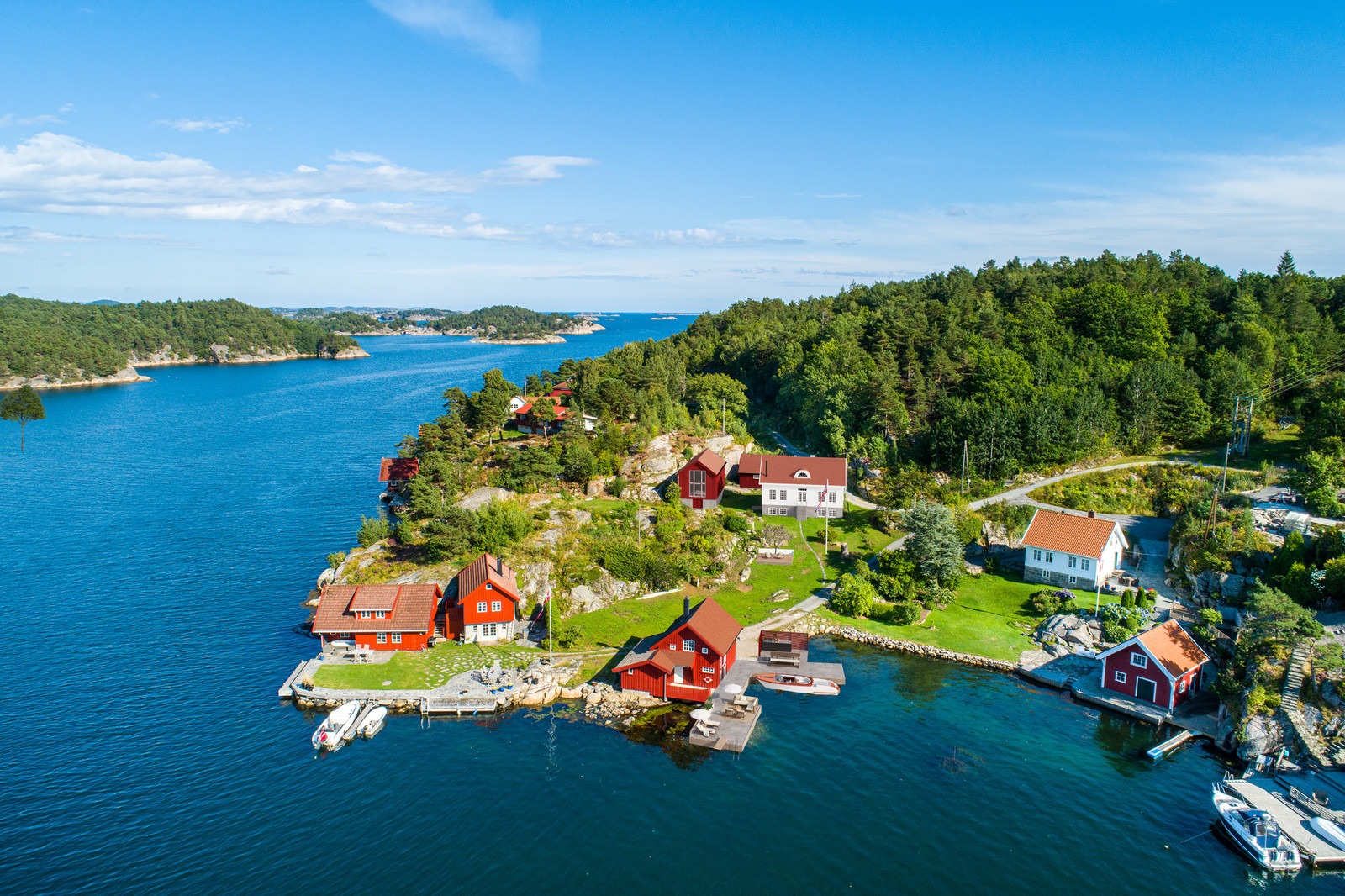 Image #0 Idyllisk landsted med strandlinje, brygge, naust, enebolig, låve, garasje.