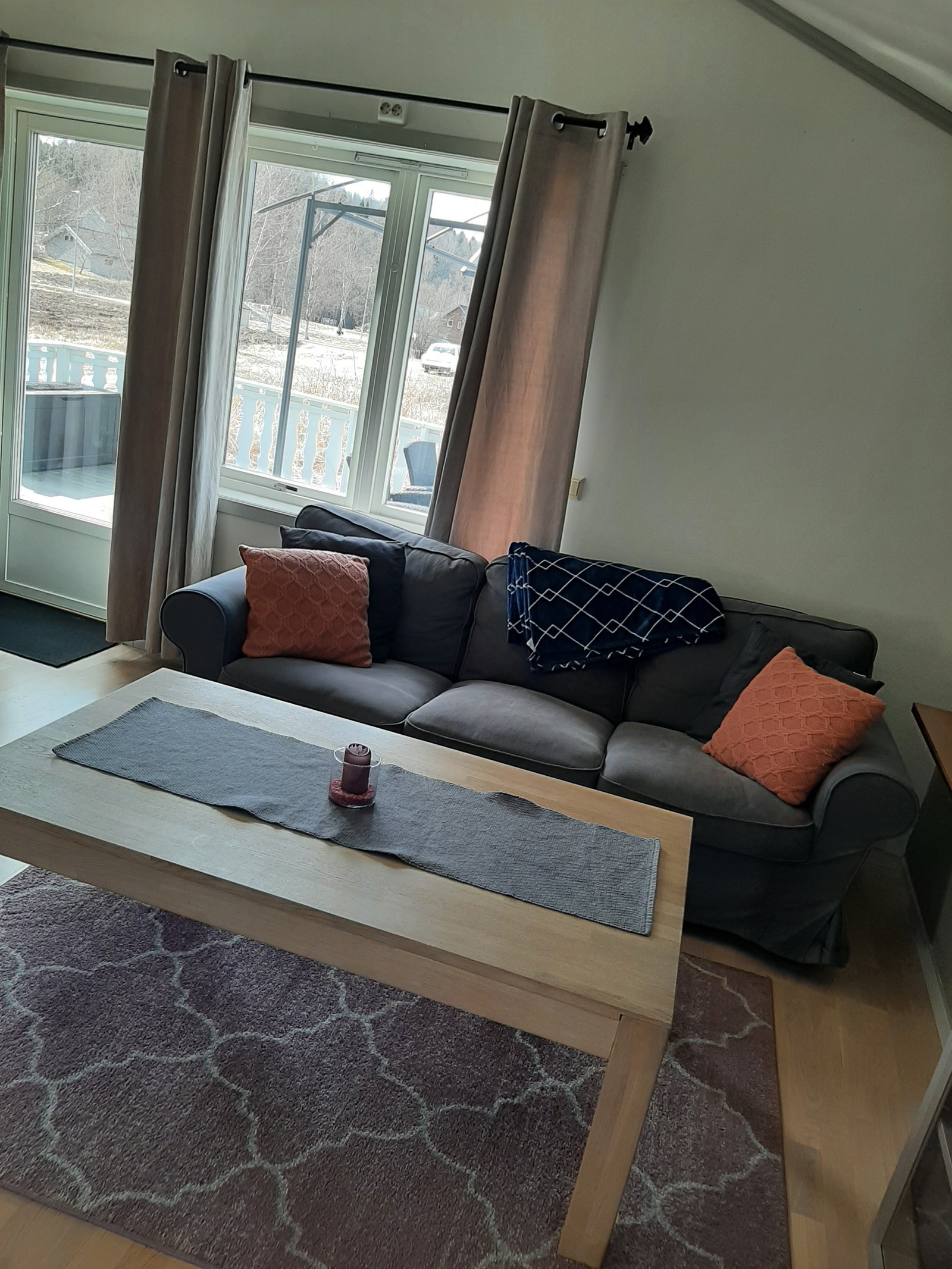 Sofa og salongbord . Verandadør ut til veranda. Galleribilde