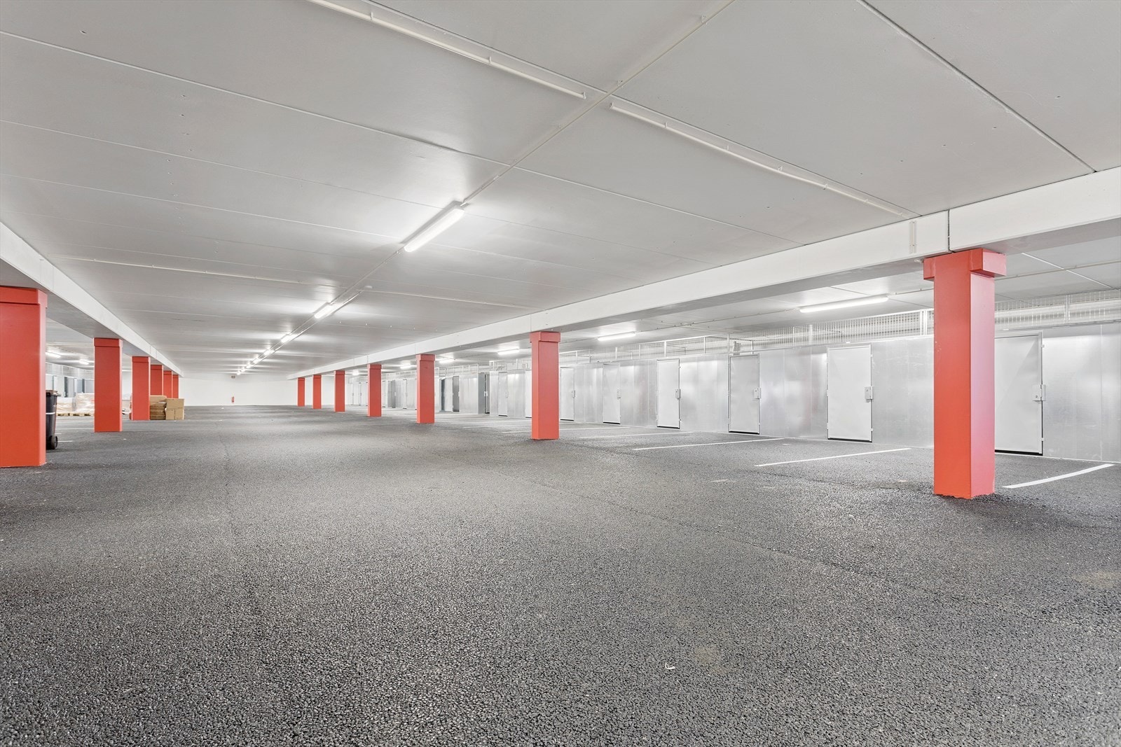 Felles parkeringskjeller hvor hver enhet har en parkeringsplass hver i tillegg til en sportsbod i bakkant av parkeringsplassen. Galleribilde