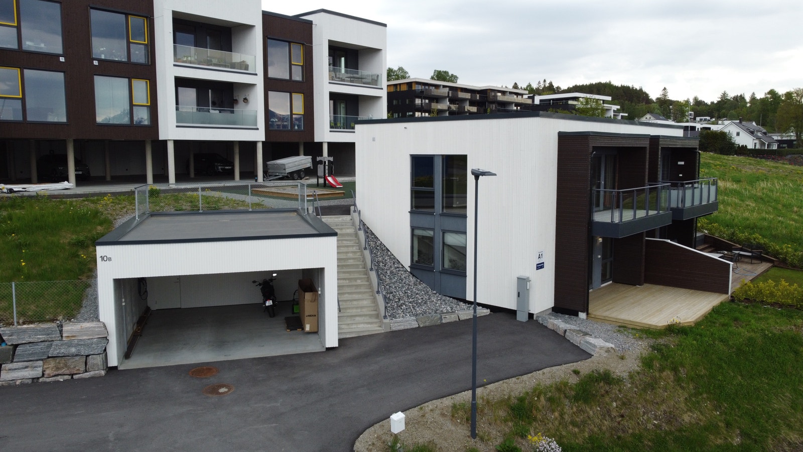 Parkering i halvpart av garasje med utvendig bod i bakkant. Ferdig opparbeidet uteområde. Galleribilde