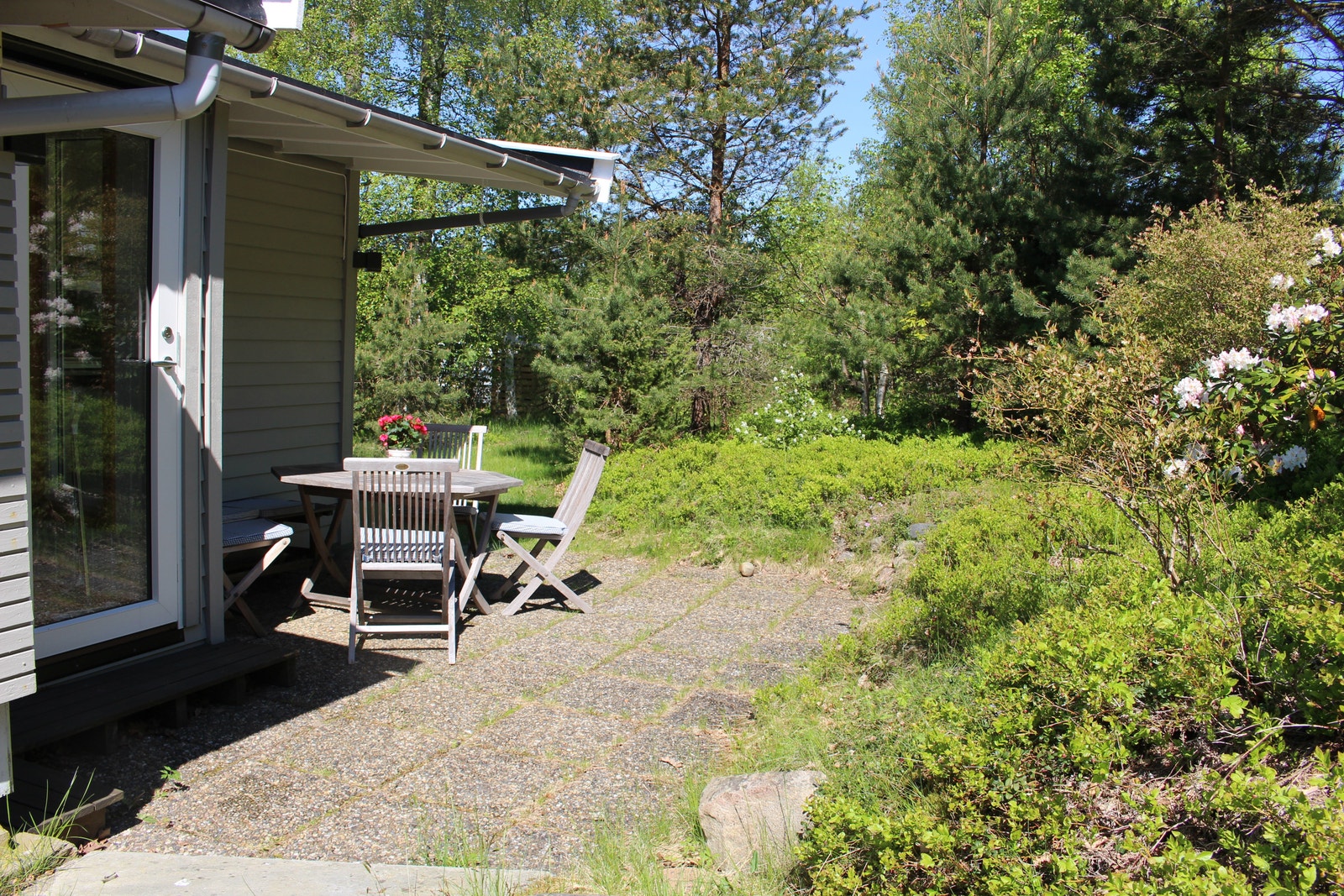 frokost plass og inngang til hytta. Parkeringsplassen er i bak kant og adkomsten er plan med gress og heller. Galleribilde