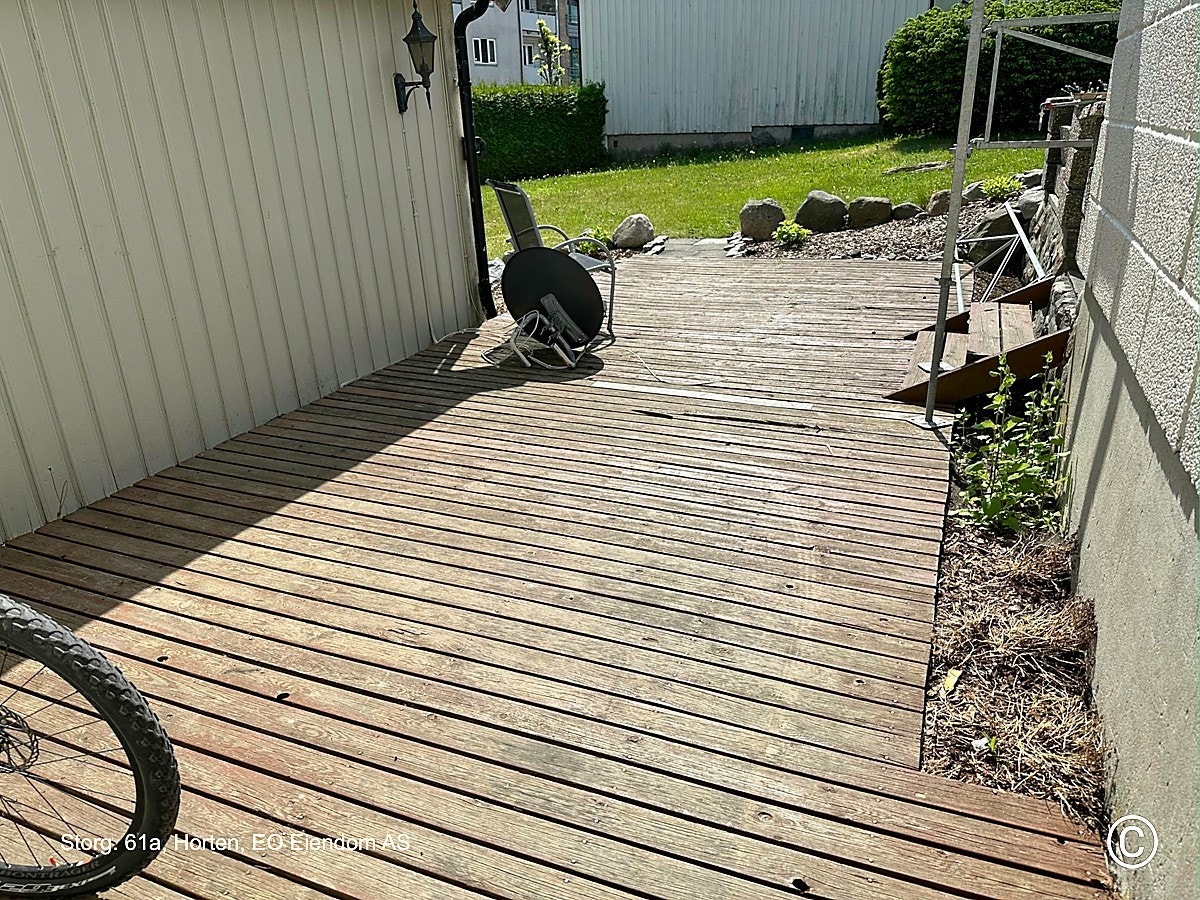 Uteplatting for leilighetene (3 leiligheter i bygget). Ligger på husets vestside med videre gang til tilhørende hade som ligger sør for bygget.
Denne leiligheten har i tillegg egen privat liten platting på østsiden av bygget. Galleribilde