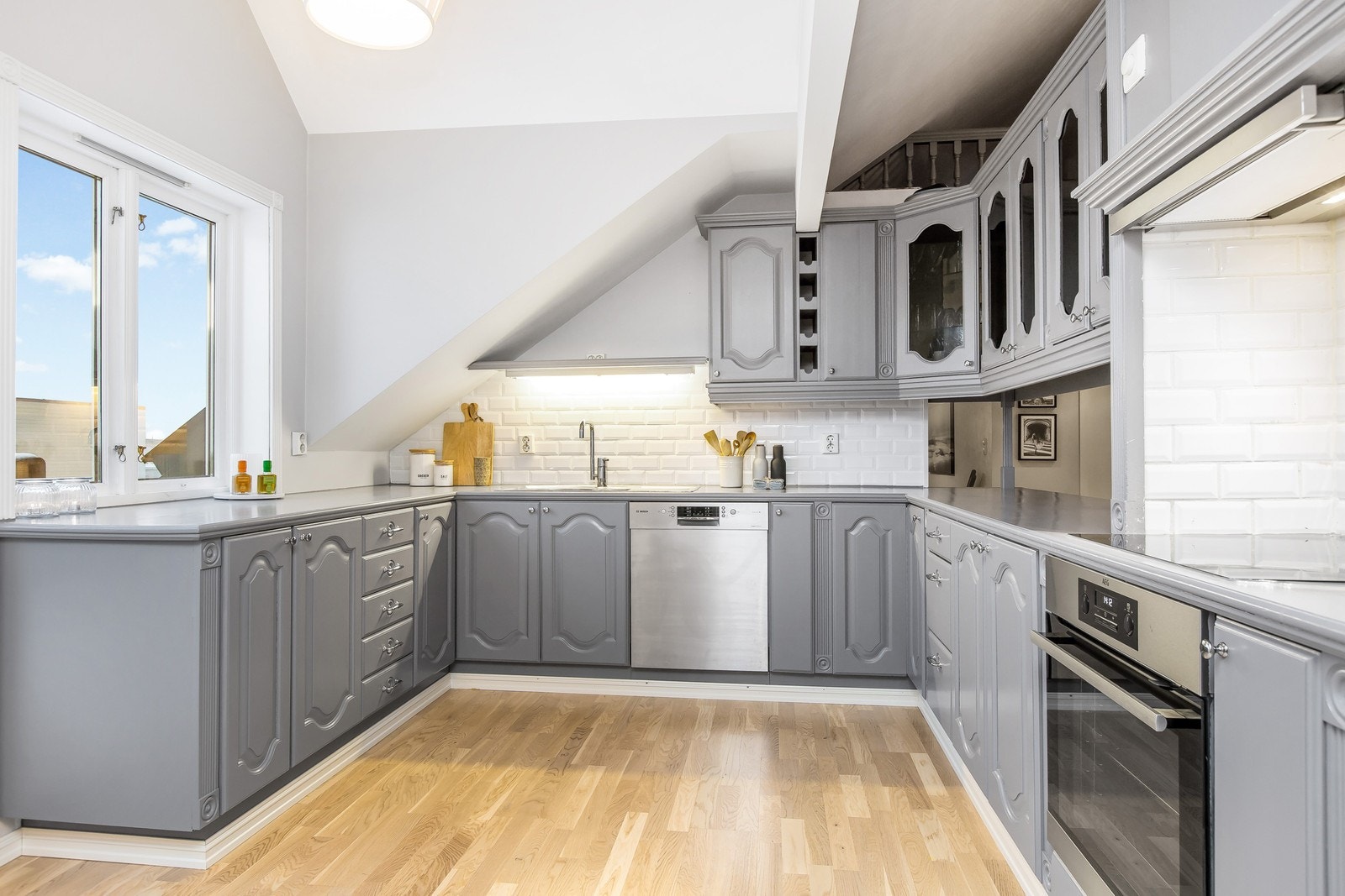 Kjøkken - her er alle hvitevarer - stort kjøleskap, fryser, nyere stekeovn, induksjonstopp og oppvaskmaskin Galleribilde