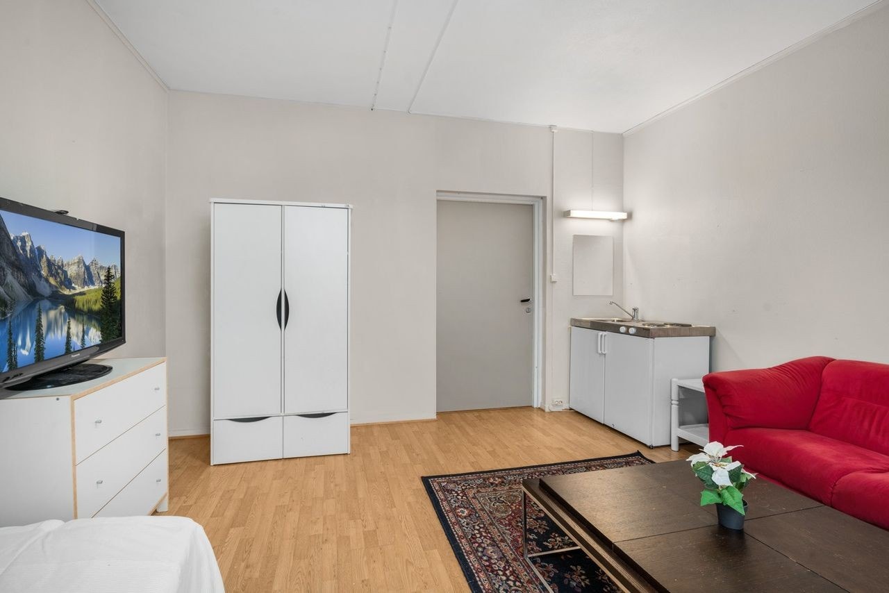 Hybelkjøkken med slette fronter i ett soverom i 1.etasje med benkebeslag i rustfritt stål med nedfelt kum. Koketopp og minikjøleskap medfølger. Galleribilde