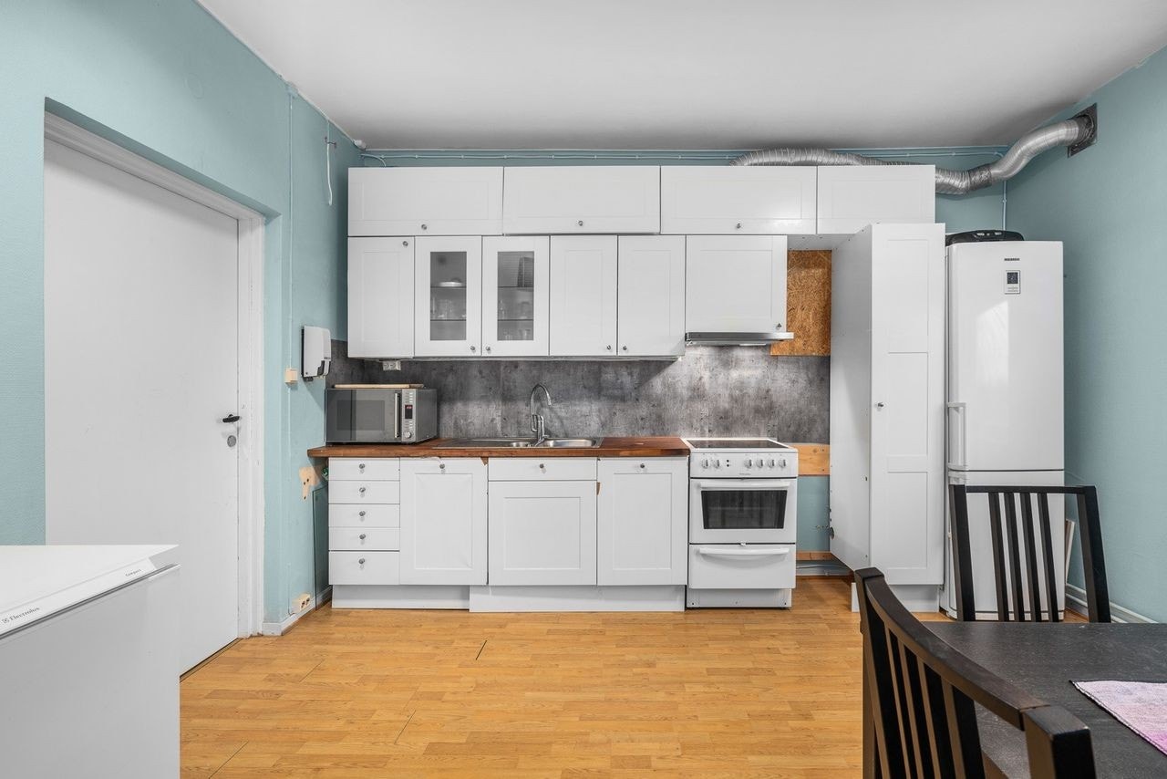 Kjøkken i 2. etasje med profilerte skuffe- og skapfronter. Enkelte glassfronter i overskap. Vinylbelegg på vegg over benkeskap. Heltre benkeplate med nedfelt kum i rustfritt stål. Galleribilde