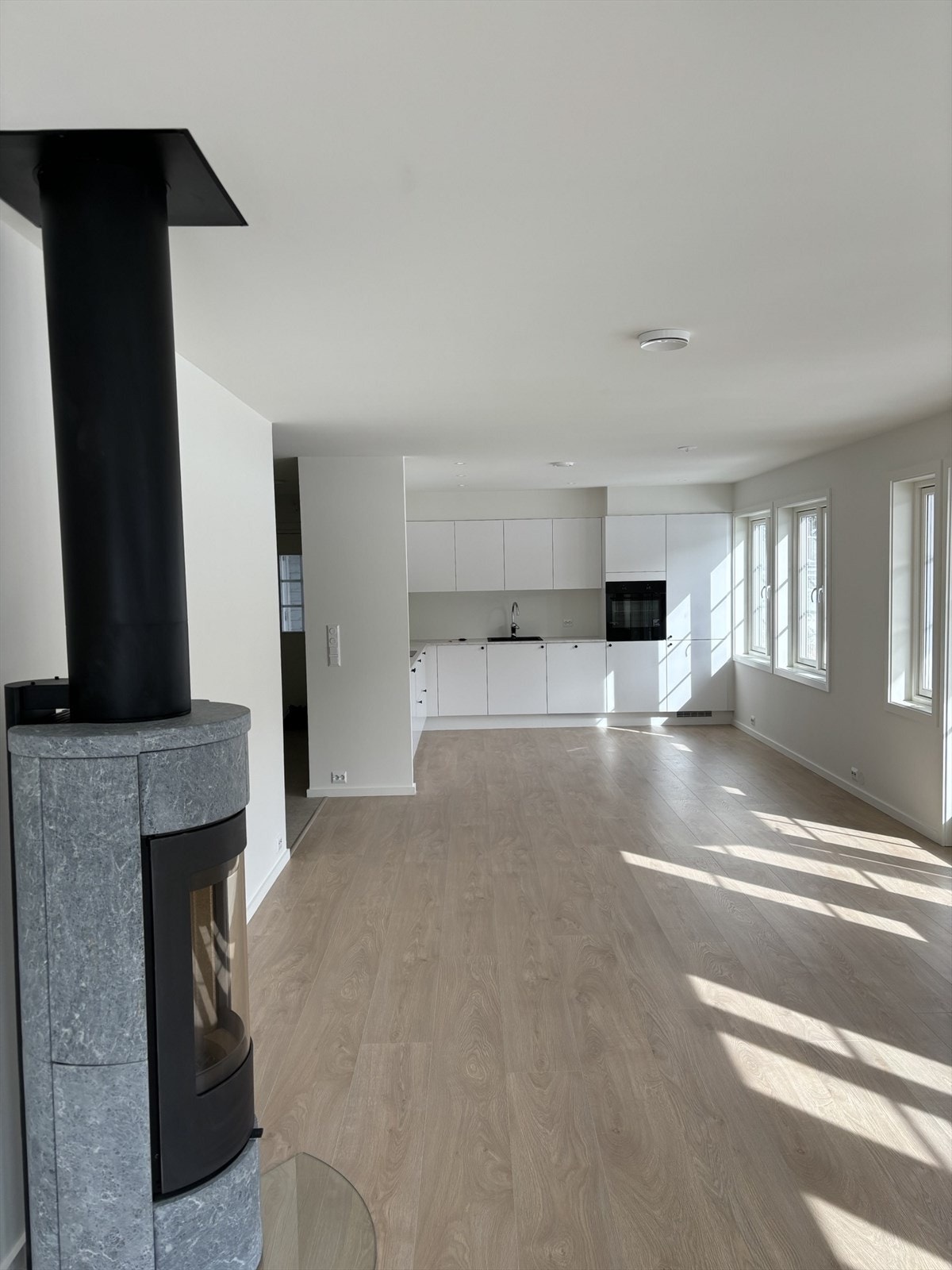 Lys stue med flott vedovn i kleberstein Galleribilde