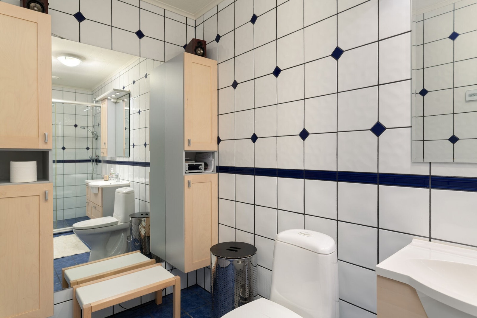 Badet er utstyrt med toalett, servant på innredning og dusjhjørne. Galleribilde