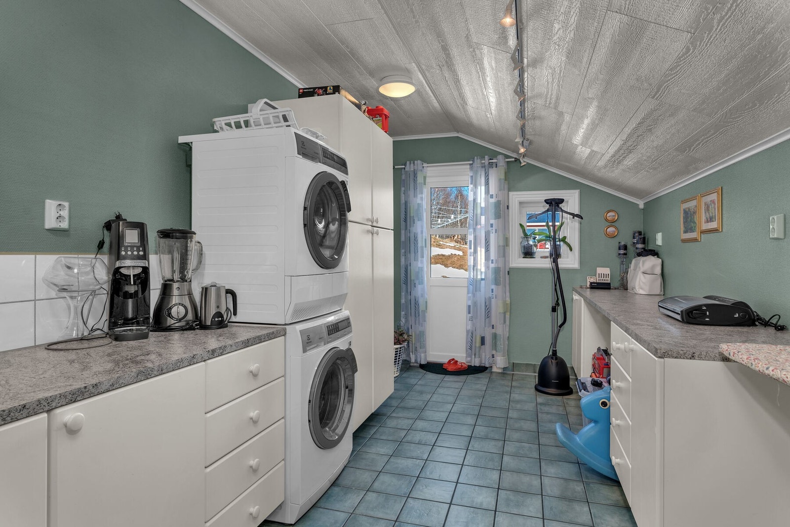 Vaskerom av god størrelse, med opplegg for vaskemaskin og innredning med god skap- og benkeplass med nedfelt skyllekar. Det er også en egen utgang. Galleribilde