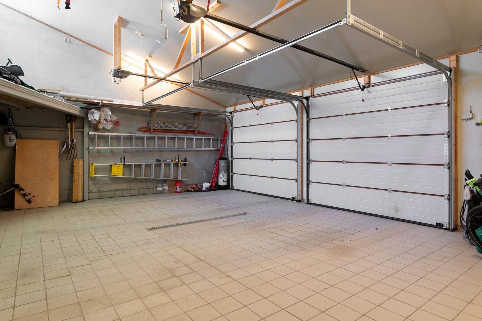 Romslig garasje med flislagt gulv og elbil-lader. Galleribilde