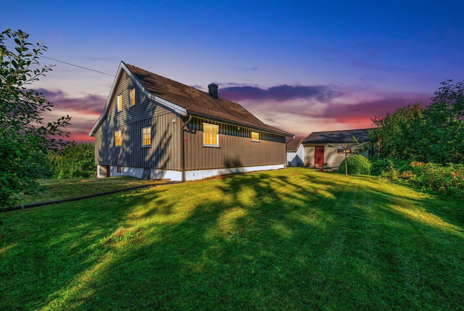 Tomten avgrenses på to sider av skog, på nedsiden går Styrivegen, og på nordsiden bak uthuset er nærmeste nabo. Galleribilde