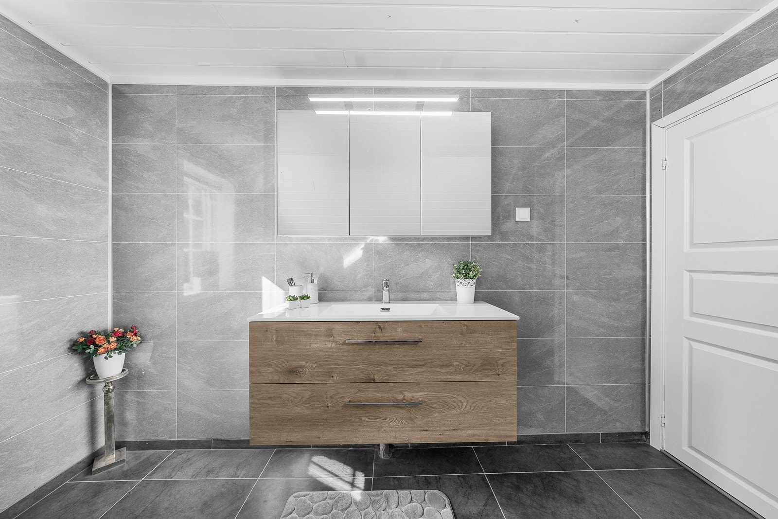 Flott baderomsmøbel med servant, oppbevaring i skuffer og skap, og belysning. Galleribilde