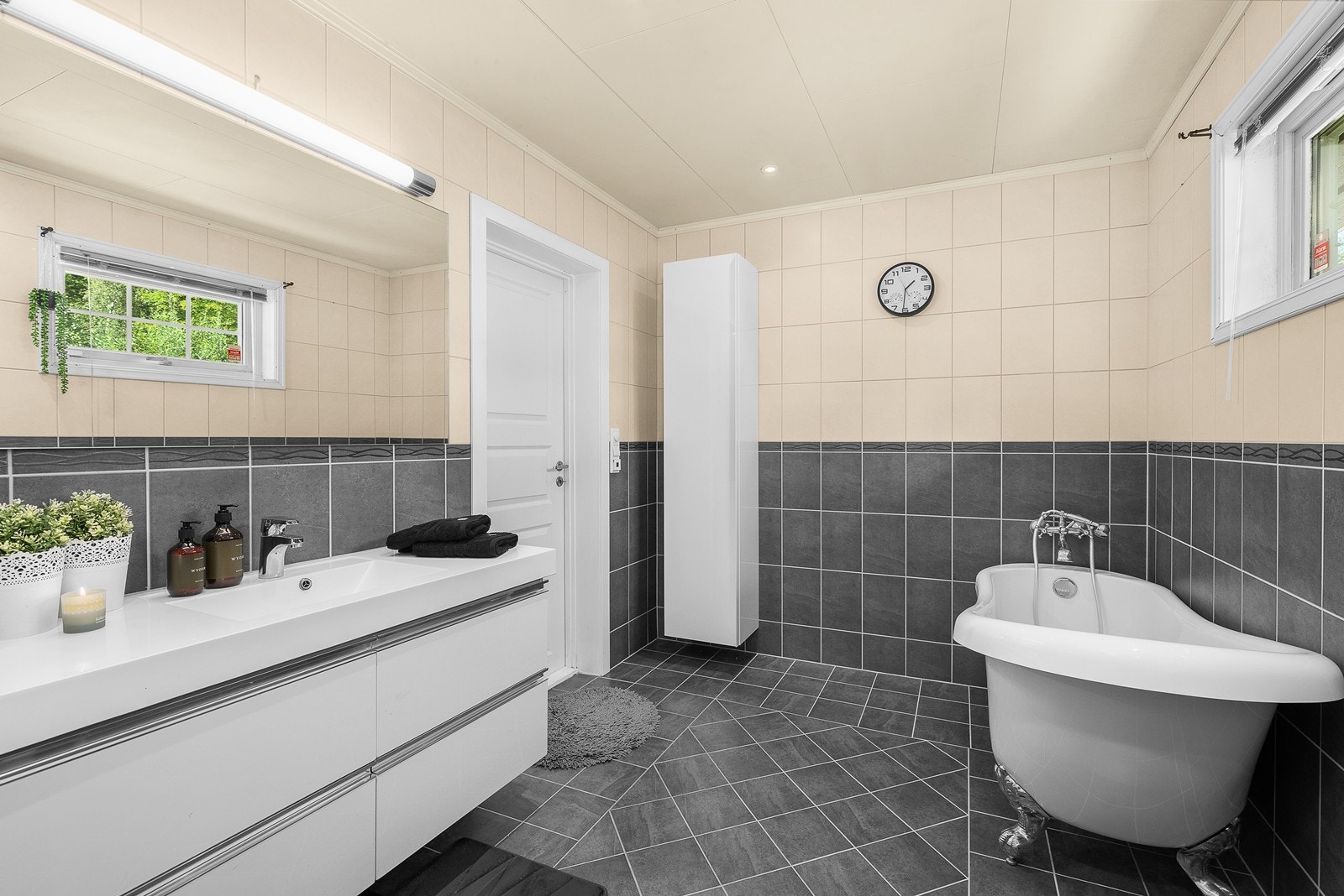 Badet i førsteetasjen er pent flislagt med baderomsmøbel, badekar, dusj og gulvstående toalett. Galleribilde