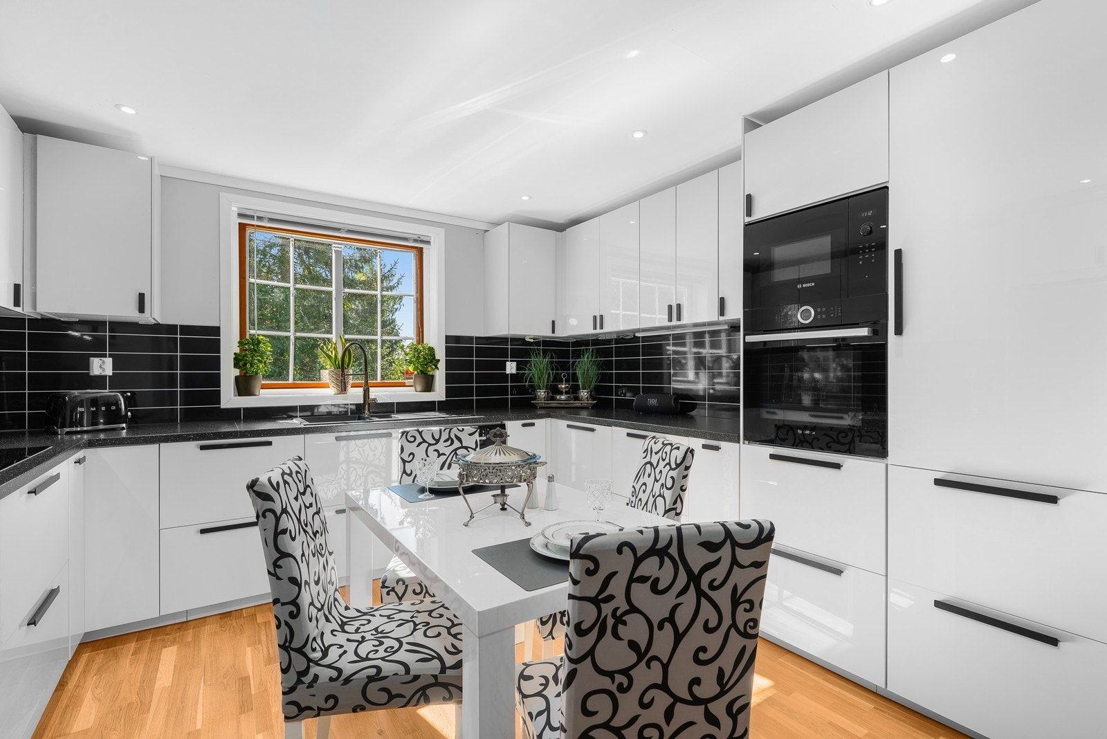 Kjøkkenet er stilrent med lyse fronter i høyglans, kombinert med en mørk benkeplate. Galleribilde