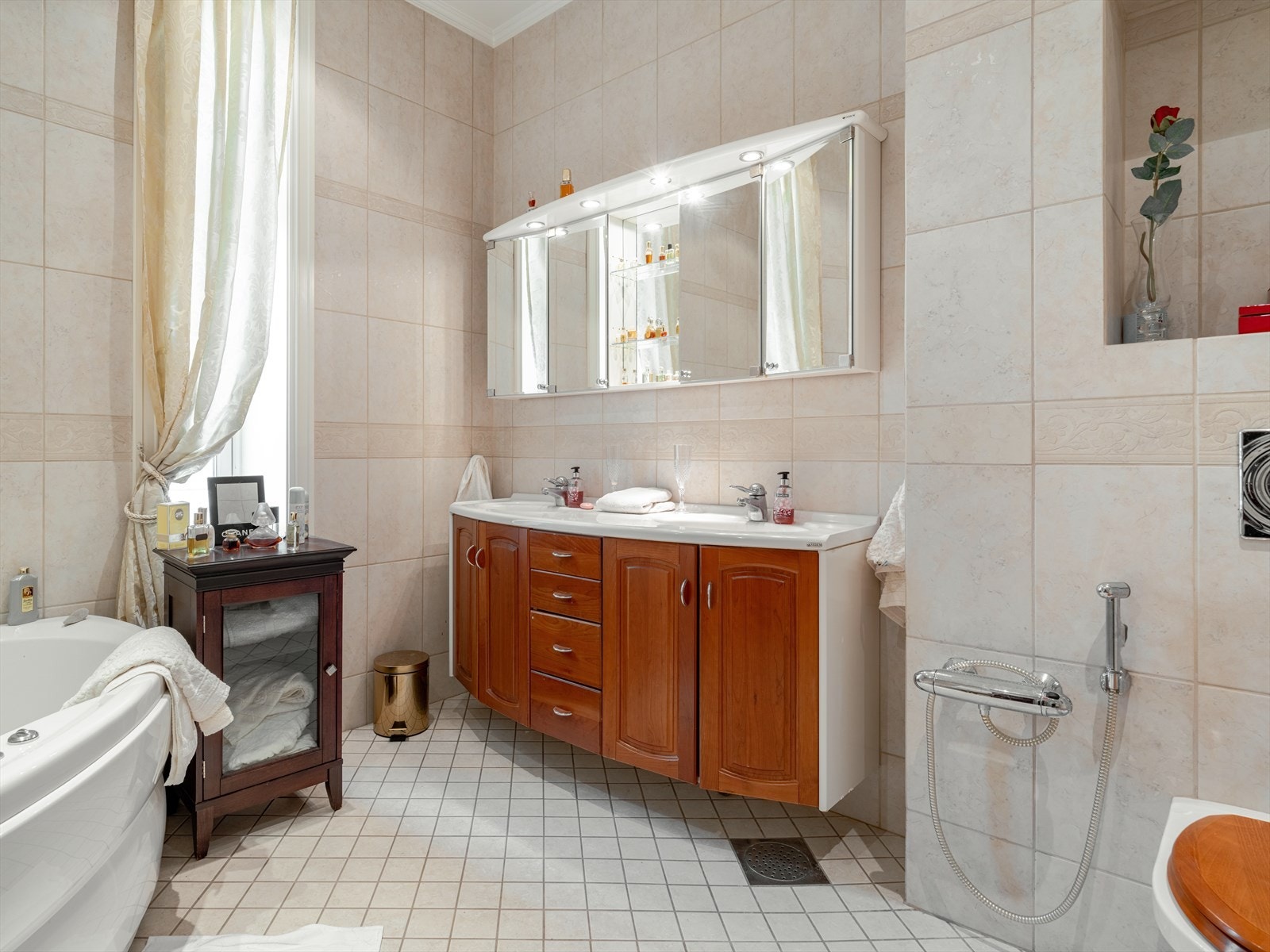 Flislagt bad med boblebad og dusjnisje. Dobbelservant og speilskap. Galleribilde