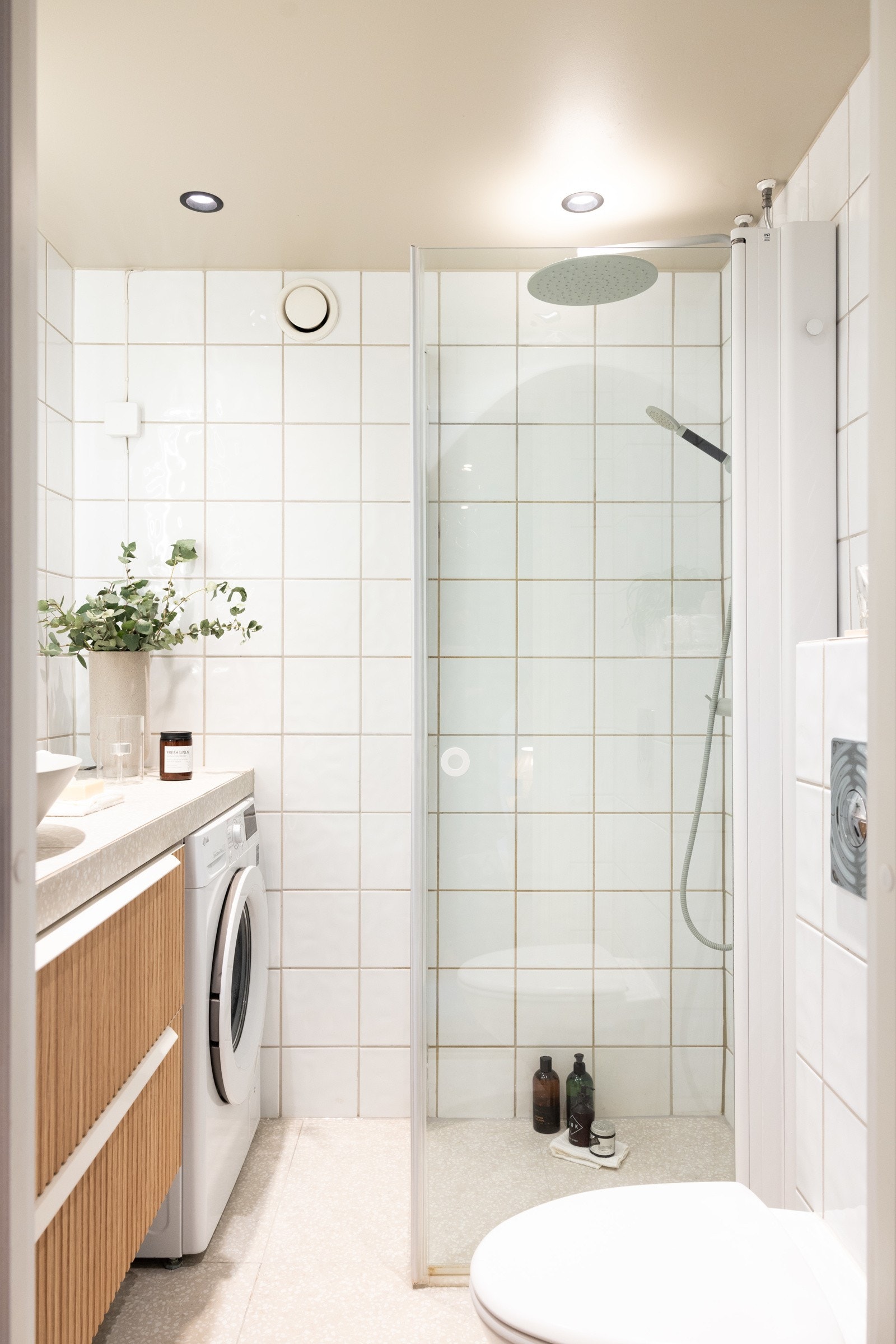 Badet har en moderne innredning med vegghengt toalett, dusjhjørne, vask og tilkoblingsmuligheter for vaskemaskin. Galleribilde