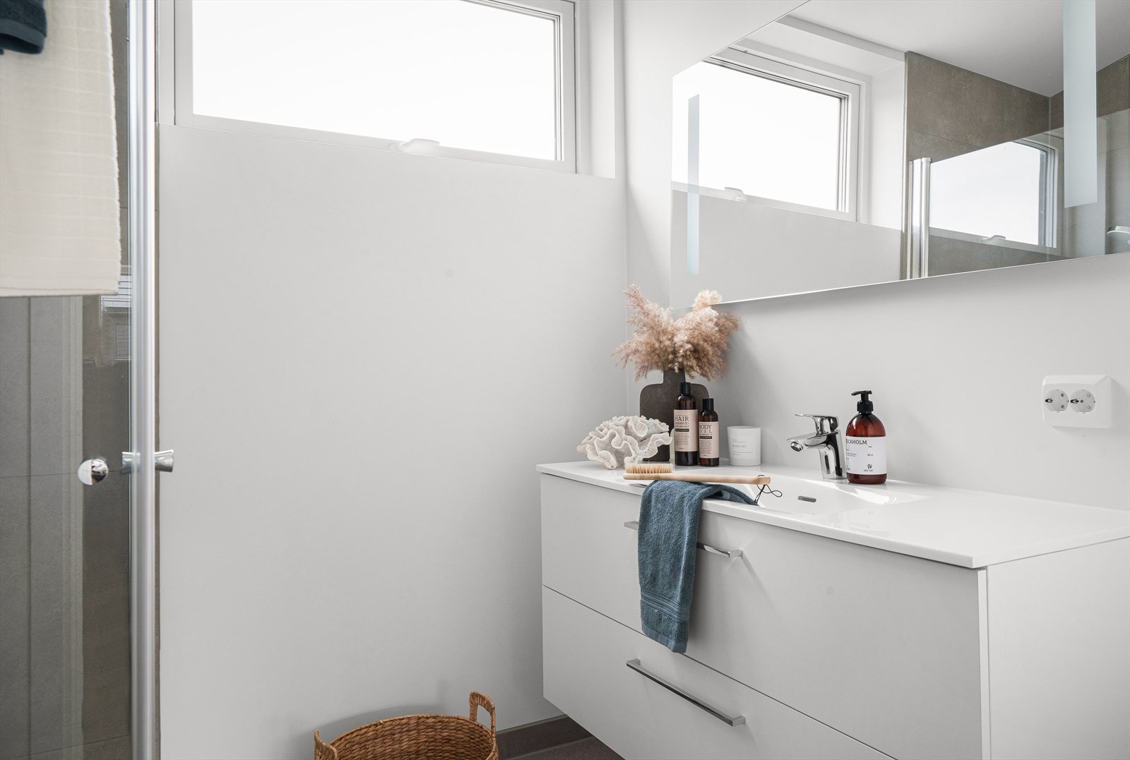 Badet er nøytralt utført, og inneholder seksjon m/servant, vegghengt toalett og dusjkabinett. Galleribilde