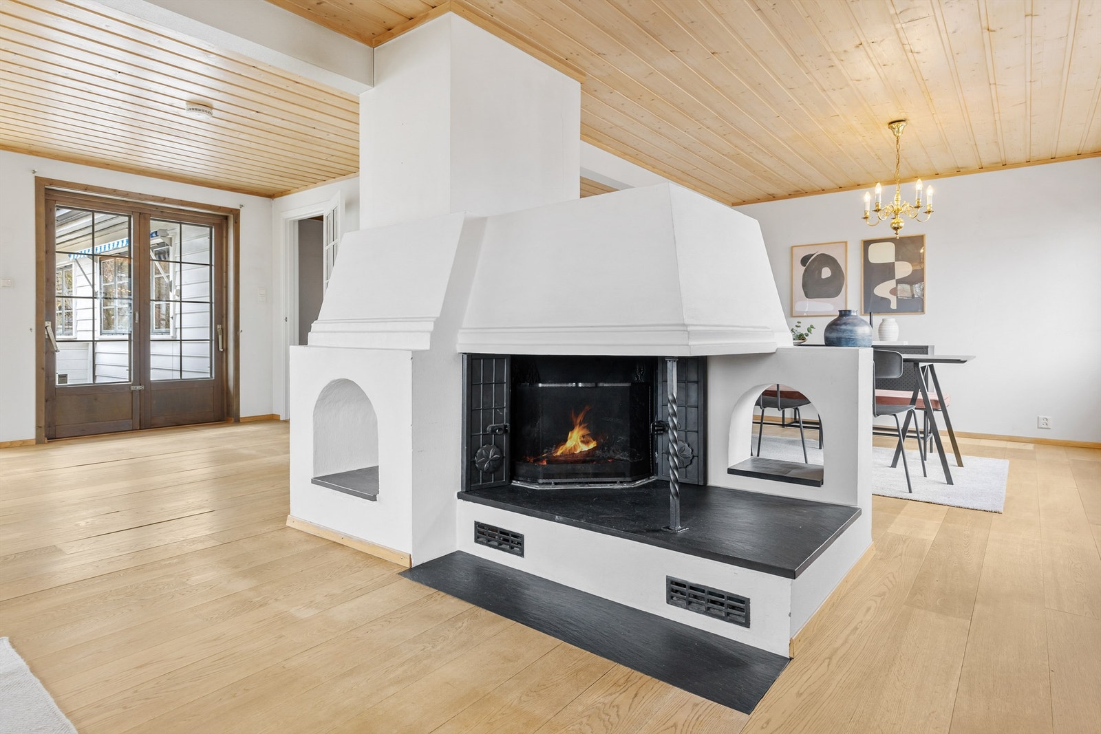 Midt i rommet er det en peis, som fungerer fint som en romdeler. Flammer er redigert inn av fotograf. Galleribilde