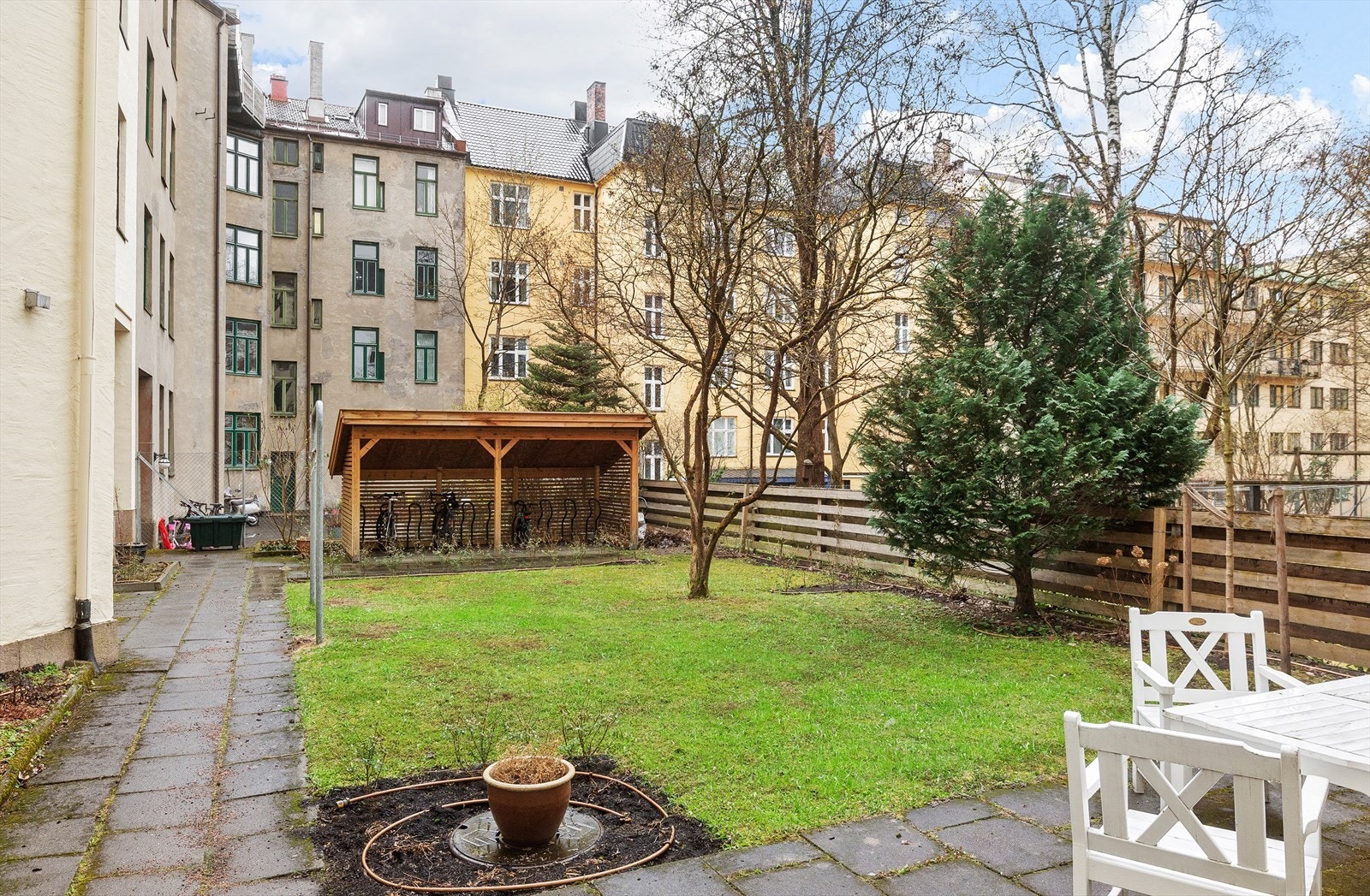 Indre avskjermet gårdsrom opparbeidet med betongheller, bruksplen, diverse beplantning, sittebenker og sykkelparkering til glede for sameiets beboere. Galleribilde