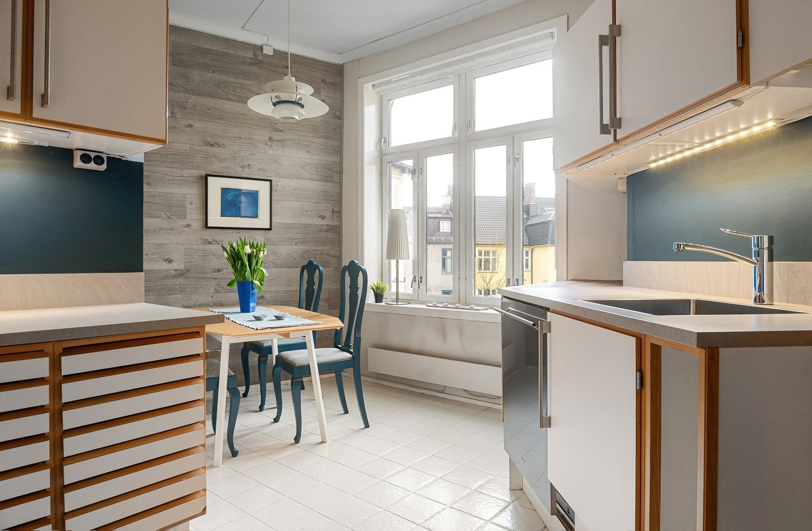 Kjøkkeninnredning fra Unoform med hvite fronter med listverk og benkeplate med planlimt vaskekum og nedfelt platetopp. Galleribilde