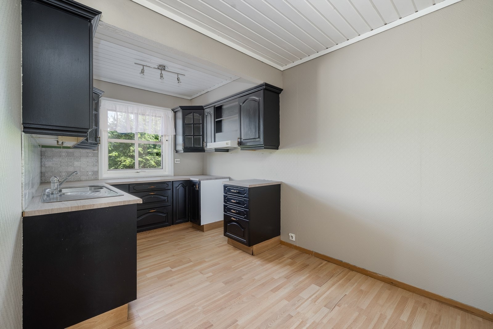 Hyggelig kjøkken med kjøkkeninnredning fra byggeår. Innredningen har godt med skapplass og mørke fronter i profilert utførelse. Galleribilde