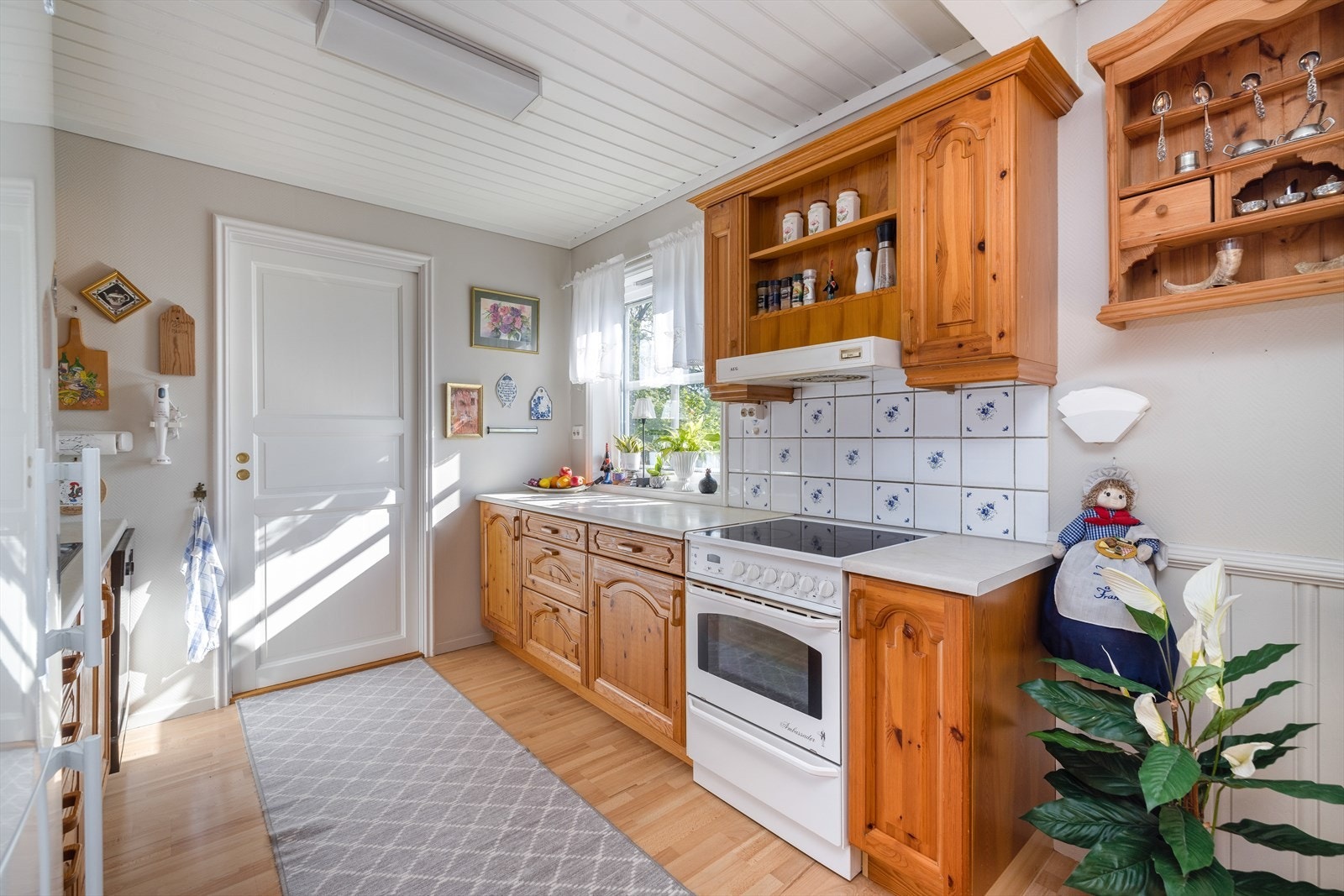 Innredningen har godt med skapplass og fronter i profilert utførelse, samt vitrinefronter. Fliser over laminat benkeplate med gode arbeidsflater. Galleribilde